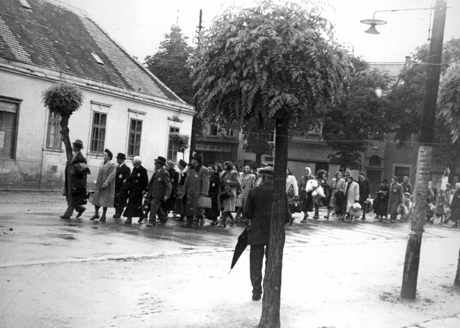 Magyarország, Kőszeg, Kossuth Lajos utca, háttérben a Fő tér házsora. Zsidók gyalogmenete a Schey Fülöp utcai gettóból a vasútállomásra 1944. június 18-án. A szombathelyi gettóba történő átszállításuk után, 1944. július 4-én, Auschwitzba deportálták a foglyokat., 1944, Fortepan, holokauszt, zsidóság, zsidóüldözés, Fortepan #200858