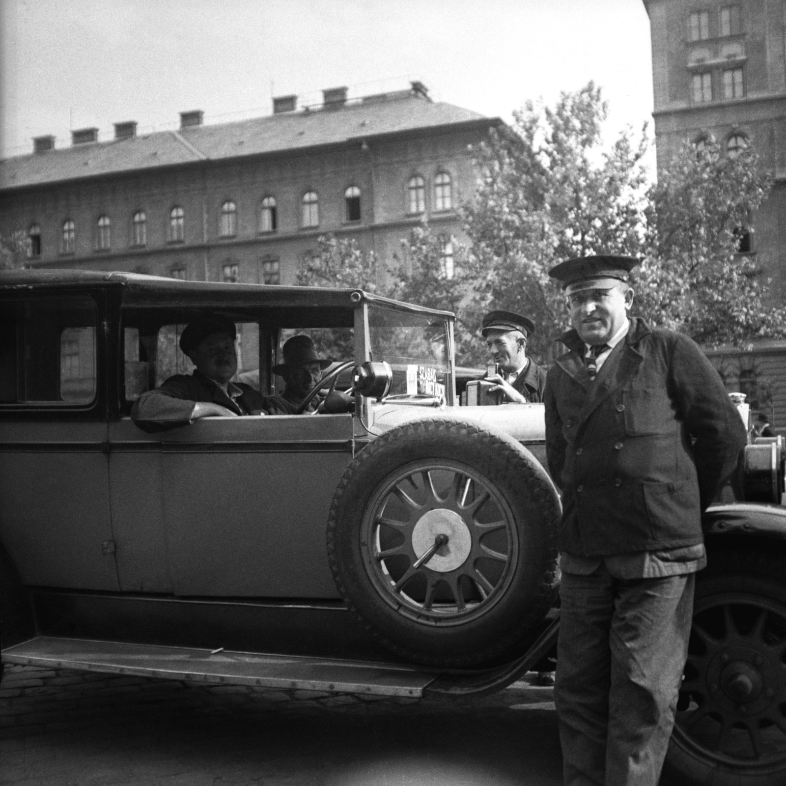 Magyarország, Budapest VIII., Kerepesi út, a Keleti pályaudvar érkezési oldalánál. Háttérben a MÁV irodaházak., 1932, Antal Dániel, taxi, sofőr, pótkerék, Budapest, sofőrsapka, Fortepan #100465