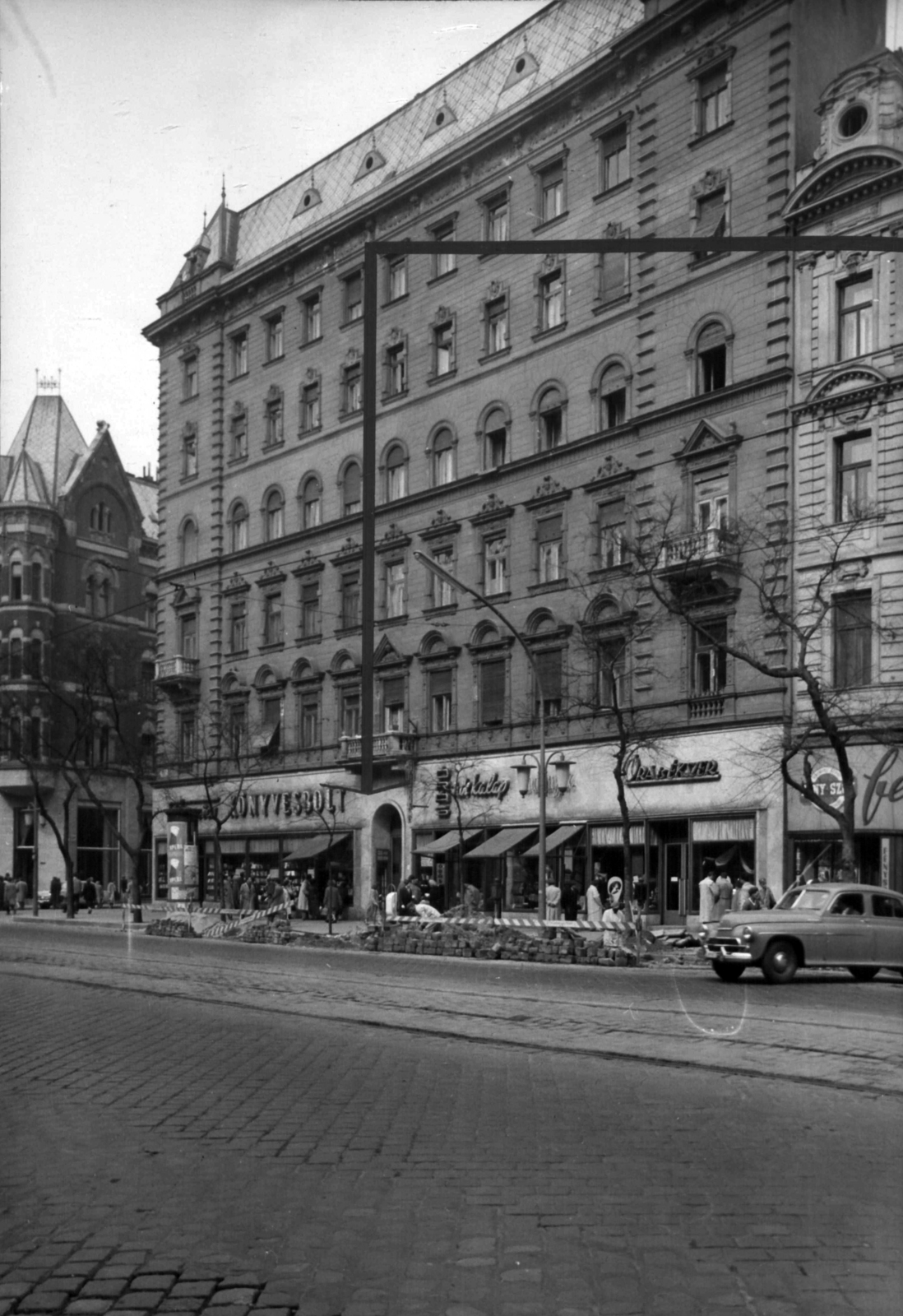 Hungary, Budapest VII., Erzsébet (Lenin) körút 17., balra a Barcsay utca. A kép forrását kérjük így adja meg: Fortepan / Budapest Főváros Levéltára. Levéltári jelzet: HU_BFL_XV_19_c_11, 1960, Budapest Főváros Levéltára / Városrendezési és Építészeti Osztályának fényképei, A Fővárosi Tanács VB Városrendezési és Építészeti Osztályának, Budapest, street repair, clockmaker, book store, Fortepan #102232
