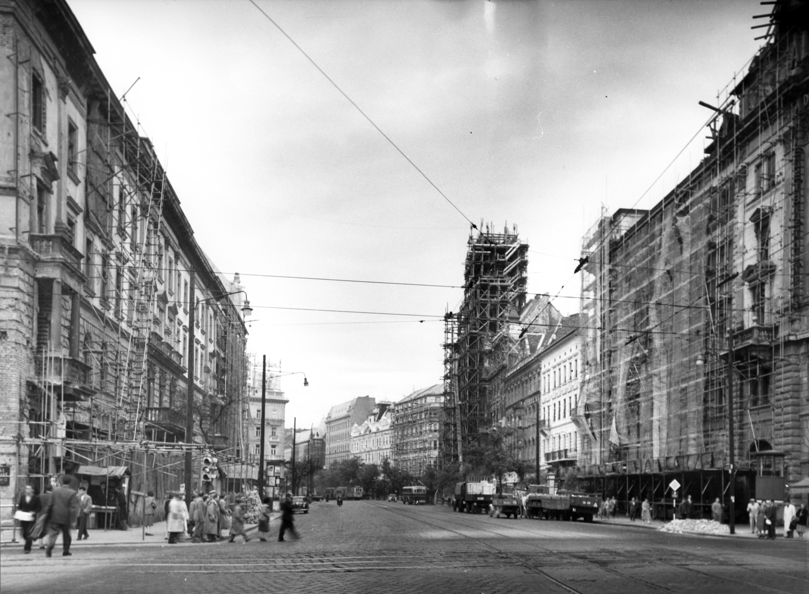 Magyarország, Budapest VIII.,Budapest VII., Erzsébet (Lenin) körút a Rákóczi úti kereszteződésből nézve, balra az EMKE ház, szemben a felállványozott New York palota. A kép forrását kérjük így adja meg: Fortepan / Budapest Főváros Levéltára. Levéltári jelzet: HU_BFL_XV_19_c_11, 1957, Budapest Főváros Levéltára / Városrendezési és Építészeti Osztályának fényképei, A Fővárosi Tanács VB Városrendezési és Építészeti Osztályának, utcakép, állvány, Budapest, Fortepan #102910