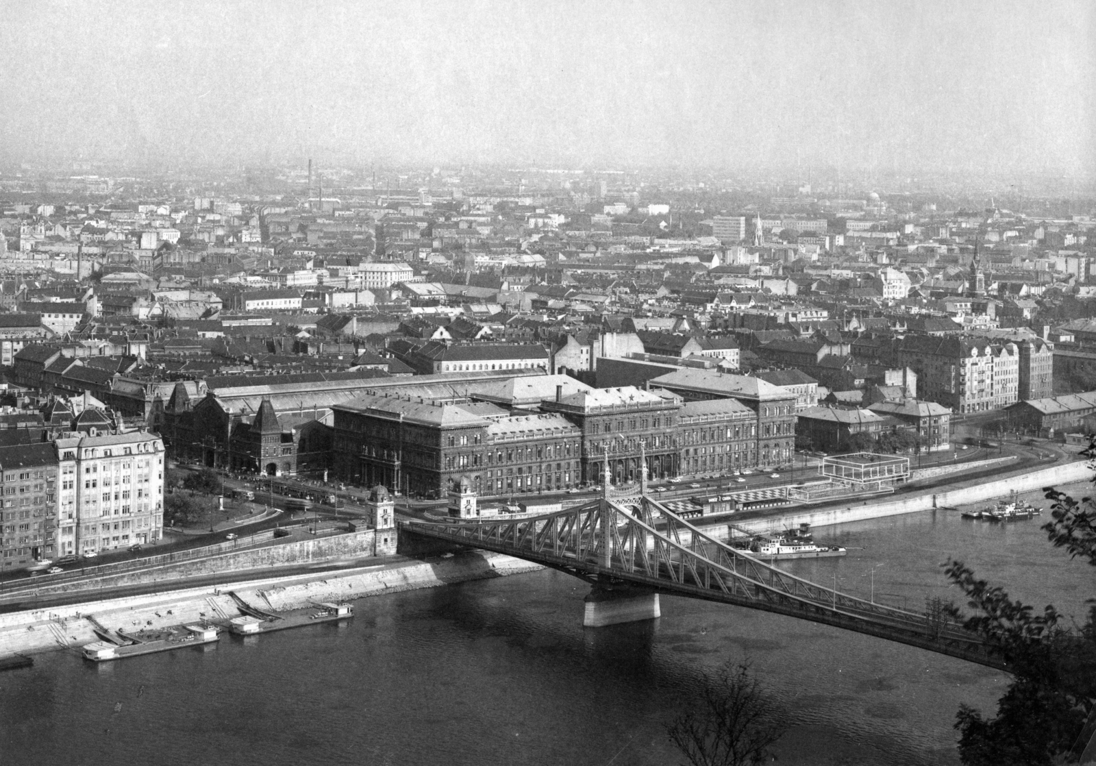 Magyarország, Budapest V.,Budapest IX.,Budapest XI., kilátás a Gellérthegyről a Szabadság híd felé. Szemben a Fővám (Dimitrov) tér és a Marx Károly Közgazdaságtudományi Egyetem (később Corvinus Egyetem) épülete. A kép forrását kérjük így adja meg: Fortepan / Budapest Főváros Levéltára. Levéltári jelzet: HU_BFL_XV_19_c_11, 1967, Budapest Főváros Levéltára / Városrendezési és Építészeti Osztályának fényképei, A Fővárosi Tanács VB Városrendezési és Építészeti Osztályának, híd, egyetem, látkép, rakpart, Duna, Budapest, függőhíd, Fortepan #103009