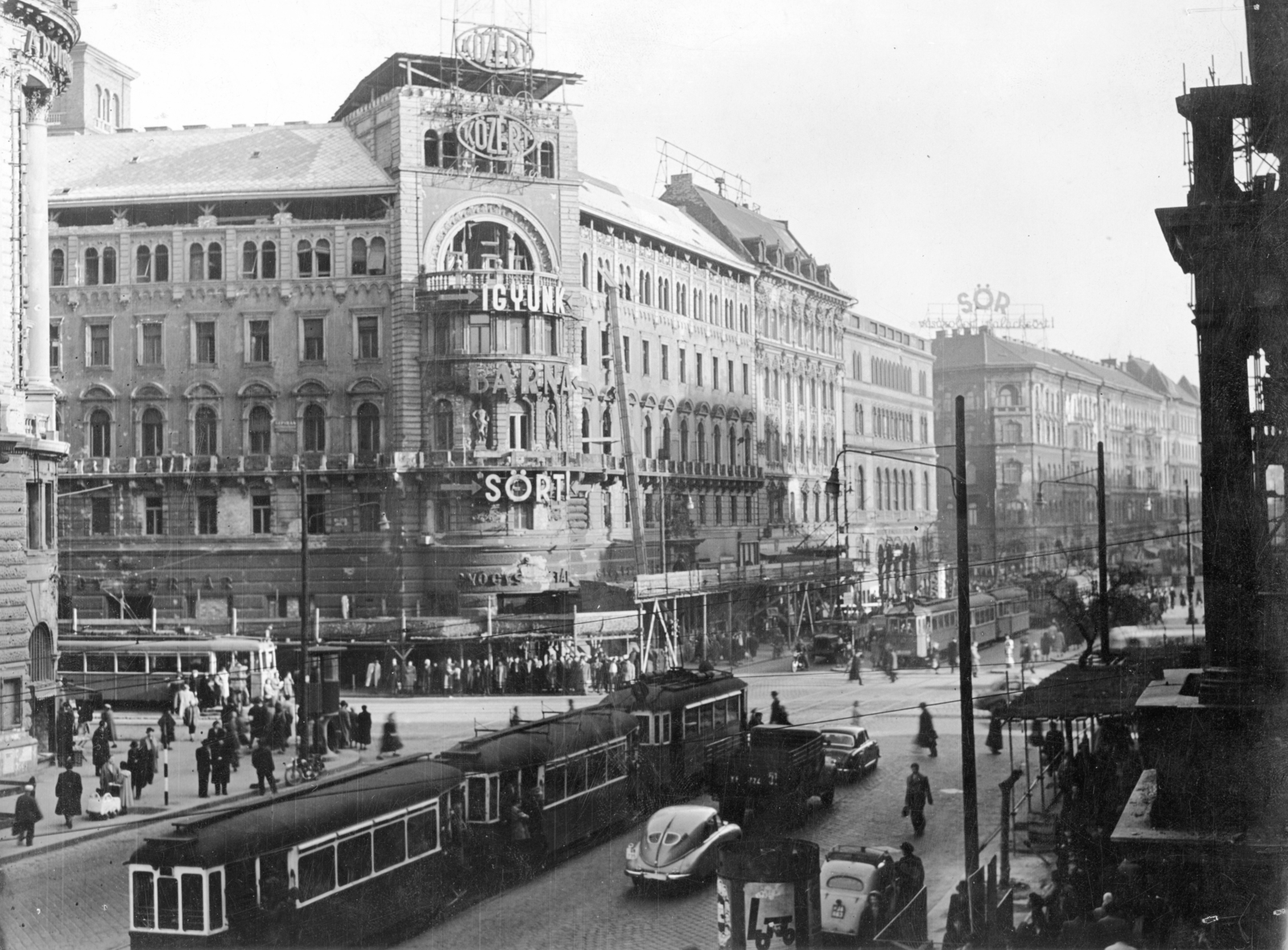 Hungary, Budapest VIII.,Budapest VII., Rákóczi út - Nagykörút kereszteződés az Erzsébet (Lenin) körútról a József körút felé nézve. A kép forrását kérjük így adja meg: Fortepan / Budapest Főváros Levéltára. Levéltári jelzet: HU_BFL_XV_19_c_11, 1958, Budapest Főváros Levéltára / Városrendezési és Építészeti Osztályának fényképei, A Fővárosi Tanács VB Városrendezési és Építészeti Osztályának, ad, traffic, baby carriage, pedestrian, commercial vehicle, street view, genre painting, taxicab, tram, ad pillar, pharmacy, beer, lamp post, cobblestones, automobile, scaffolding, Budapest, roof rack, grocery store, Közért Company, Fortepan #103526
