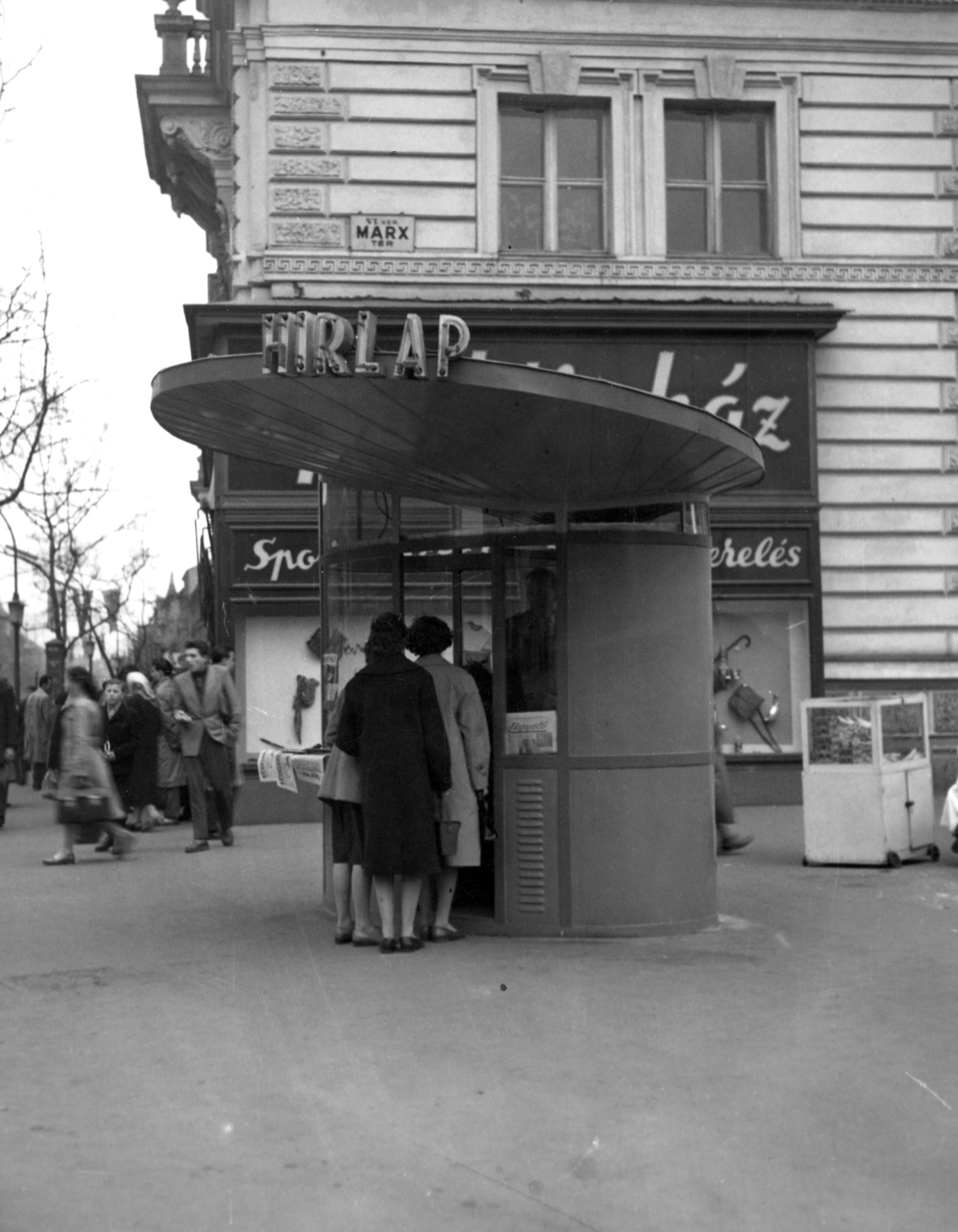 Hungary, Budapest VI., Teréz (Lenin) körút - Nyugati (Marx) tér sarok, hírlapárus pavilon. Háttérben az egykori indóházból kialakított MÁV BVKH / Bevételellenőrzési, Visszatérítési és Kártérítési Hivatal. A kép forrását kérjük így adja meg: Fortepan / Budapest Főváros Levéltára. Levéltári jelzet: HU_BFL_XV_19_c_11, 1964, Budapest Főváros Levéltára / Városrendezési és Építészeti Osztályának fényképei, A Fővárosi Tanács VB Városrendezési és Építészeti Osztályának, Budapest, Fortepan #103606