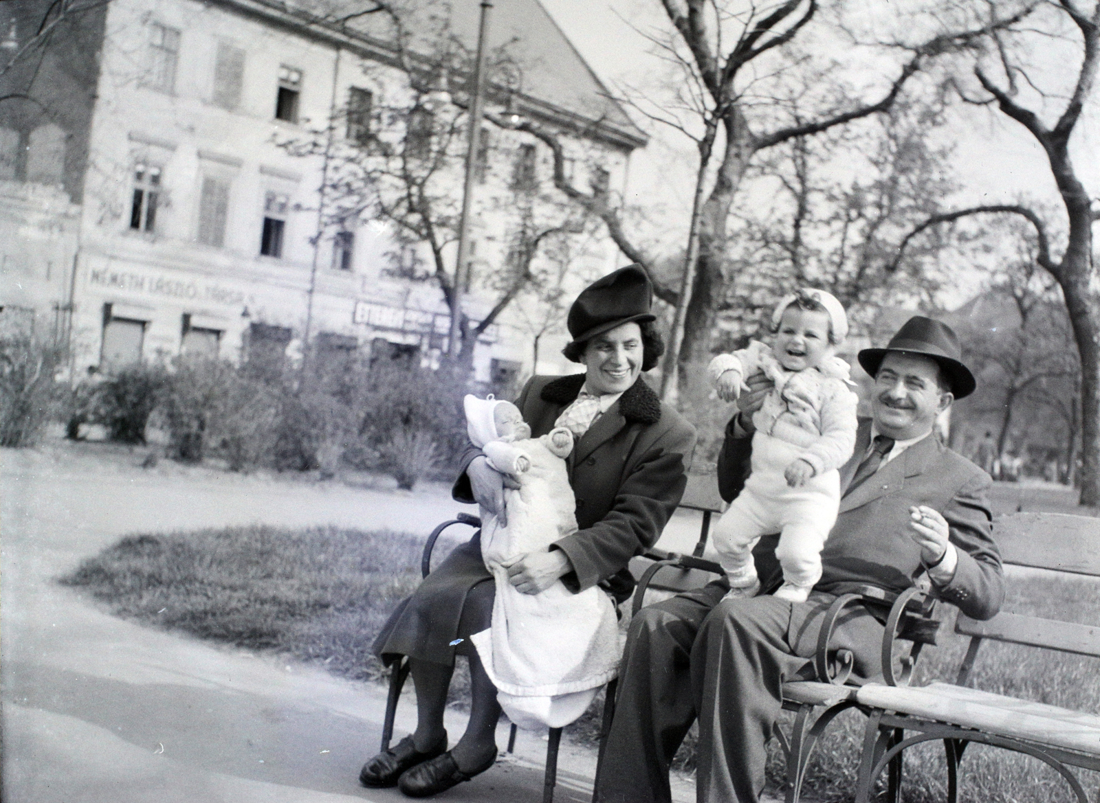 Hungary, Budapest V., Erzsébet (Sztálin) tér a Deák Ferenc tér felé nézve, háttérben balra a Kemnitzer ("Két török") ház., 1946, Hámori Gyula, Budapest, fun, bench, newborn, kid, grandparent, hold in arms, Fortepan #105040