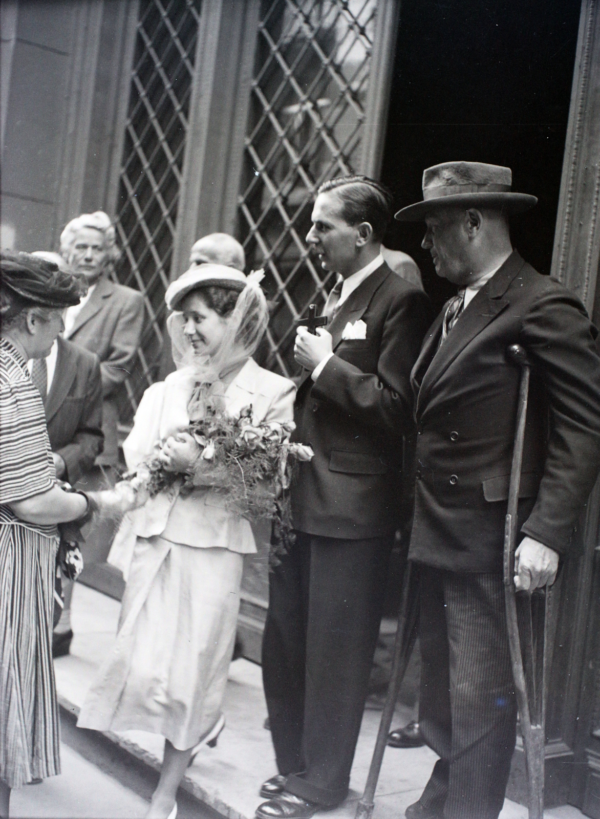 Hungary, Budapest V., Piarista utca, a felvétel a Piarista kápolnában tartott esküvő alkalmával készült a gimnázium bejáratánál., 1946, Hámori Gyula, crutch, Budapest, cross, groom, bride, Fortepan #105061