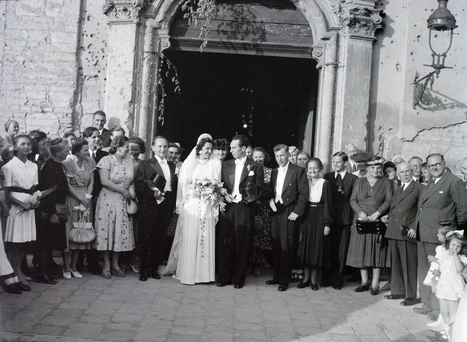 Hungary, Budapest V., Március 15. (Eskü) tér, a felvétel a Belvárosi Nagyboldogasszony Főplébánia-templom kapujánál készült., 1947, Hámori Gyula, Budapest, bride, groom, wedding ceremony, tableau, bullet hole, Fortepan #105123