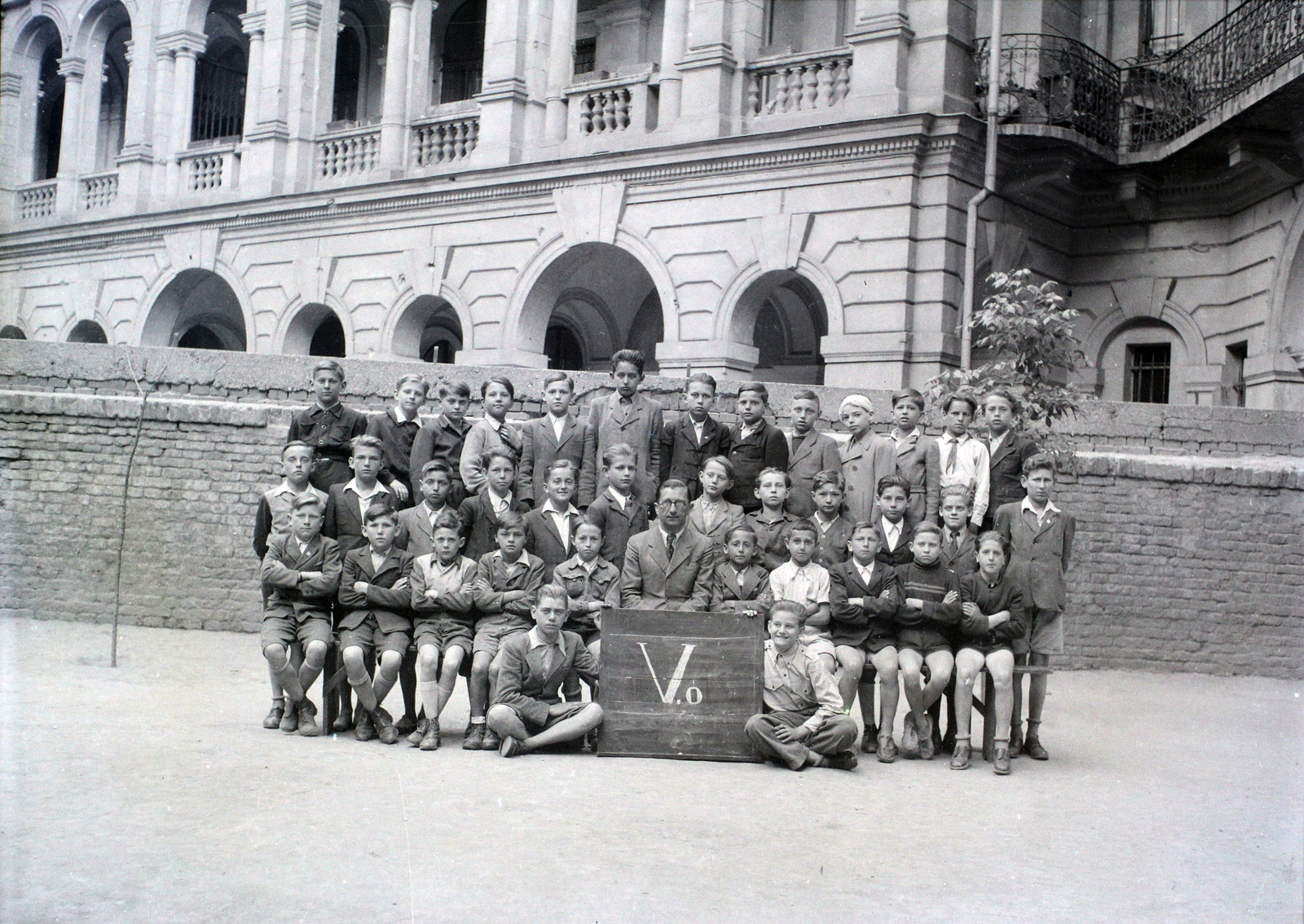 Hungary, Budapest VI., Felső erdősori Általános iskola (később Erkel Ferenc Általános Iskola) udvara, csoportkép egy ötödikes osztályról. Háttérben az Andrássy út 83–85. számú ház udvari homlokzata., 1948, Hámori Gyula, tableau, Budapest, class photo, Fortepan #105241