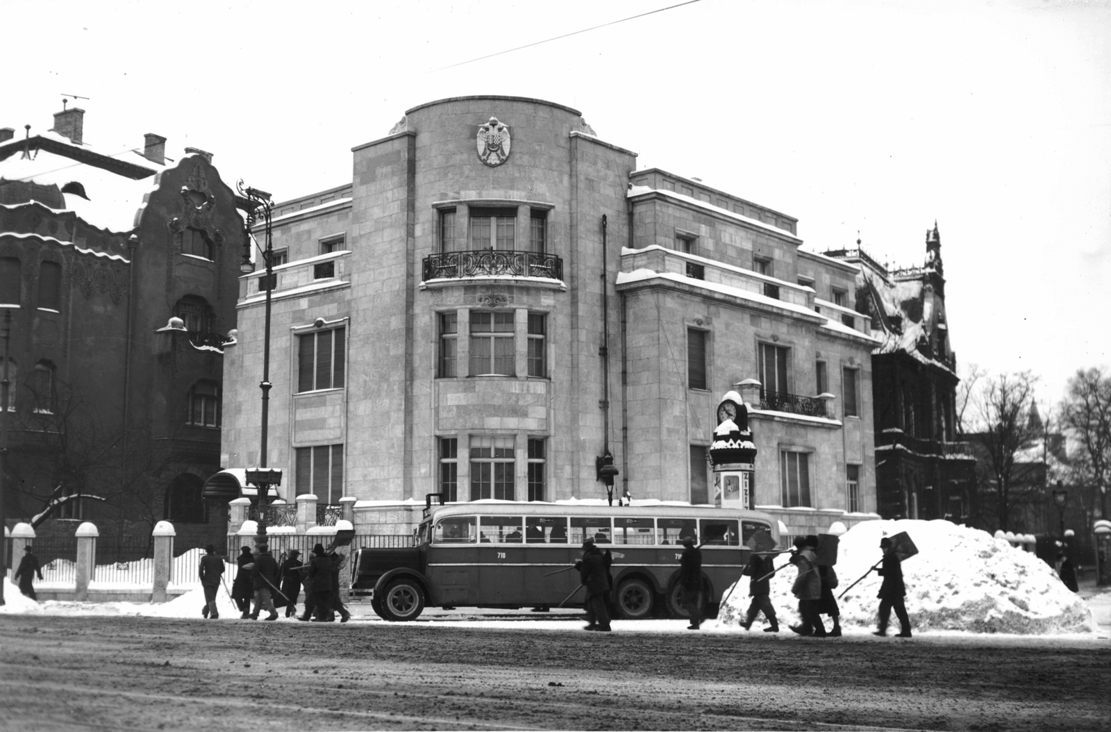 Magyarország, Budapest VI., Dózsa György (Aréna) út - Andrássy út sarok, a szerb követség épülete., 1943, Archiv für Zeitgeschichte ETH Zürich / Agnes Hirschi, Carl Lutz, autóbusz, óra, MÁVAG-márka, hirdetőoszlop, hómunka, címer, MÁVAG Ni56, hókupac, Budapest, Fortepan #105684