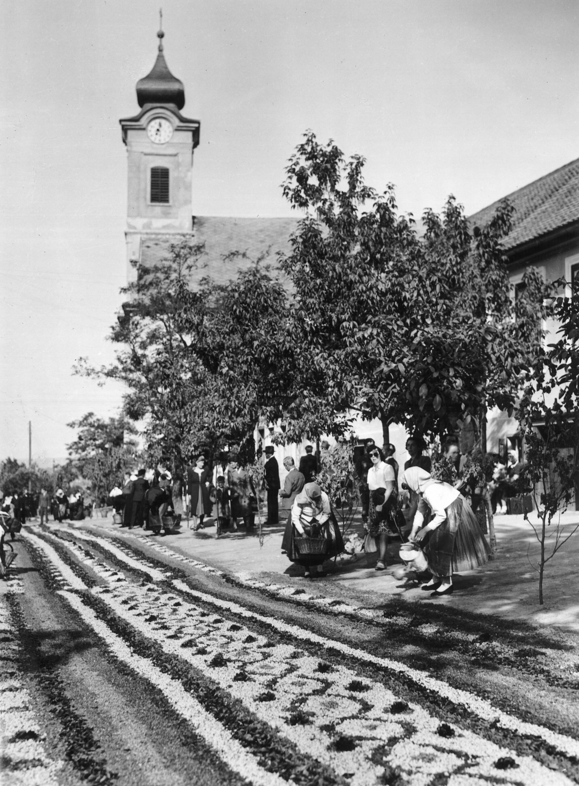 Hungary, Budaörs, Templom tér a Nepomuki Szent János-templom felé nézve. Úrnapi körmenet virágszőnyege., 1943, Archiv für Zeitgeschichte ETH Zürich / Agnes Hirschi, Carl Lutz, folk costume, flower carpet, church clock, Fortepan #105692