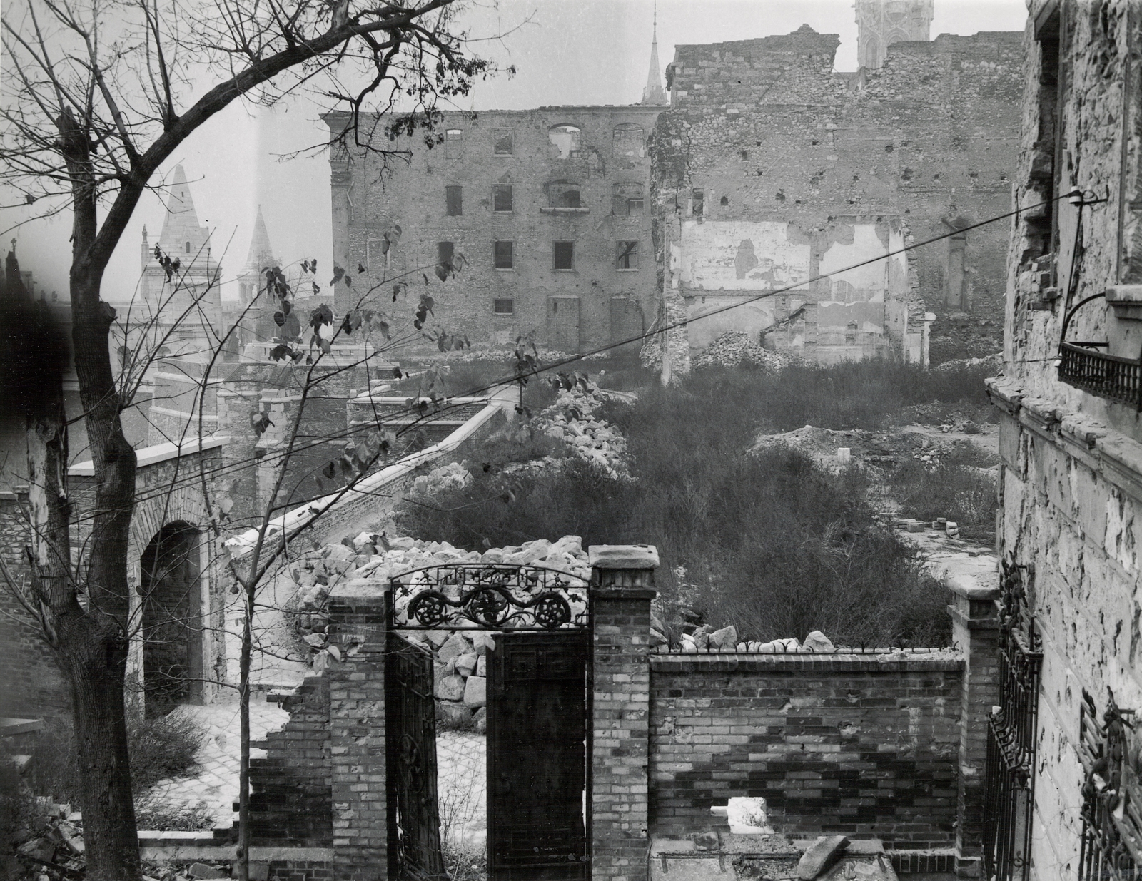 Hungary, Budapest I., Táncsics Mihály (Verbőczy) utca 1., kilátás a korábbi brit követség teraszáról a Halászbástya felé. Balra a Boldog XI. Ince pápa (Ibolya) utcai kapunál az Iskola lépcső., 1945, Archiv für Zeitgeschichte ETH Zürich / Agnes Hirschi, Carl Lutz, war damage, forged steel door, Budapest, Fortepan #105718
