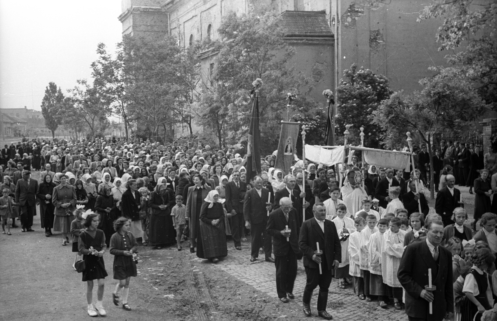 Hungary, Székesfehérvár, Havranek József (Úttörő) utca, háttérben a Szent Sebestyén-templom. Úrnapi körmenet., 1957, Hámori Gyula, flag, candle, procession, Catholic Church, old person, ritual, Fortepan #108409
