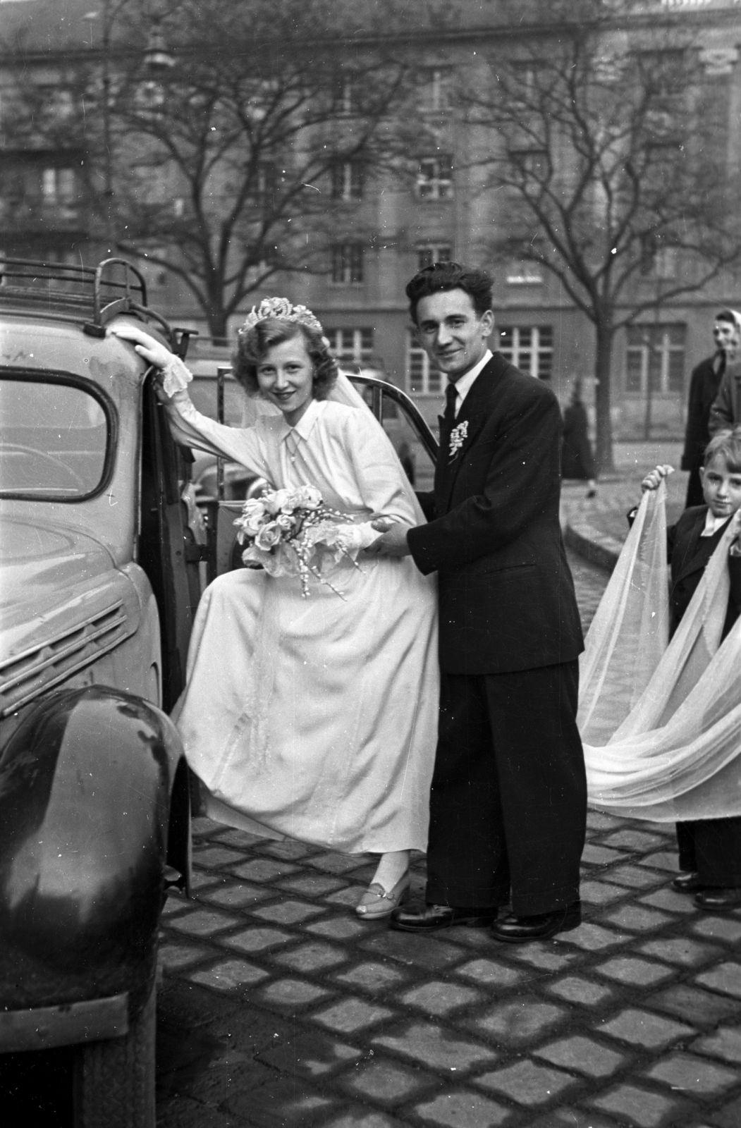 Hungary, Budapest VI.,Budapest XIII., Szent Margit (Élmunkás) tér, a felvétel az Árpád-házi Szent Margit-templom előtt készült, háttérben a Lehel utca 1., 1954, Hámori Gyula, wedding ceremony, bride, bouquet, automobile, Budapest, entering the car, Fortepan #108627