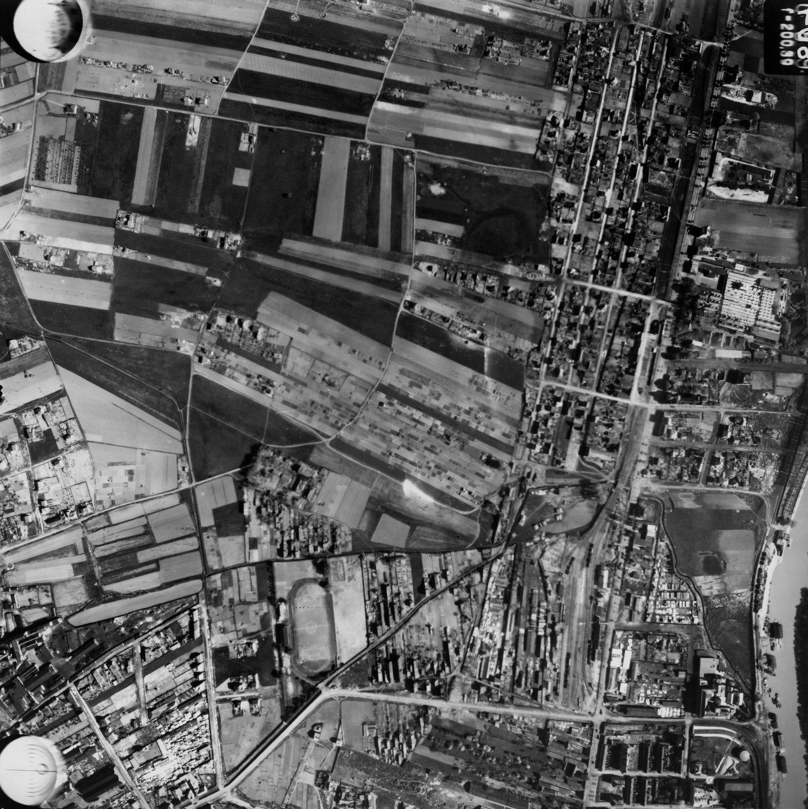 Hungary, Budapest III., légifotó, Óbuda. Lentről balról jobbra felfelé halad a Hévízi út, mellette a III.ker. TVE sporttelep. A pályával egy magasságban, kissé jobbra a Filatorigát vasútállomás van. A kép jobb szélén a Hajógyári-sziget melletti Duna-ág látszik. A felvétel 1944. április 14-én készült., 1944, Magyar Királyi Honvéd Légierő, aerial photo, Budapest, Fortepan #109066