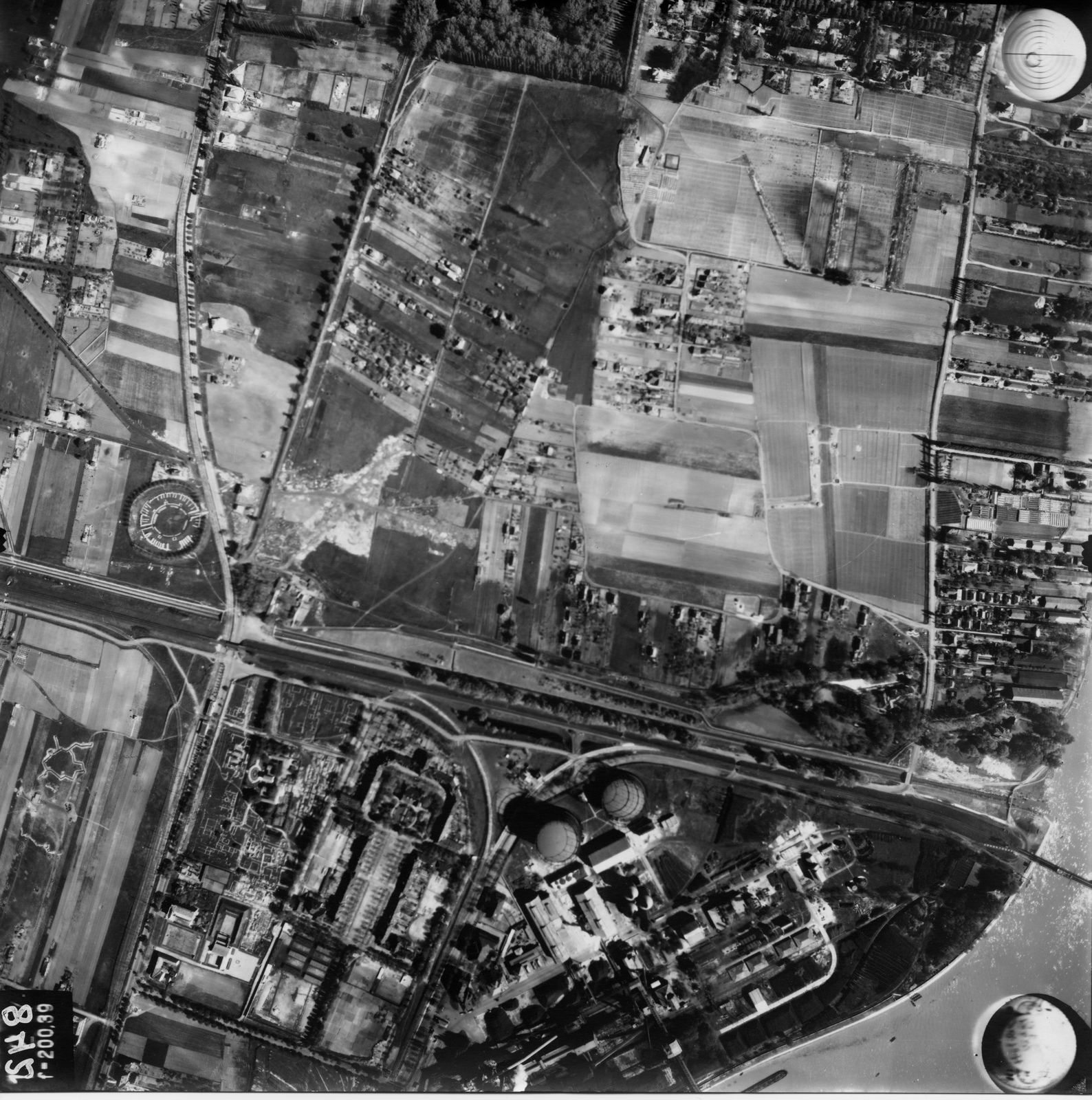 Hungary, Óbuda, Budapest III., légifotó, a képen balra a polgárvárosi amfiteátrum látható, alatta keresztben az esztergomi vasútvonal, tőle jobbra a Szentendrei út. A képen alul a Gázgyár, felette jobbra a Római-part. A felvétel 1944. április 14-én készült., 1944, Magyar Királyi Honvéd Légierő, aerial photo, gas factory, Budapest, Fortepan #109080