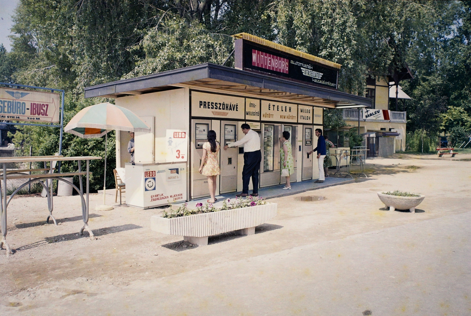 Hungary, Balatonfüred, kikötő, Utasellátó automata büfé a Vitorlás étterem mellett., 1971, Bauer Sándor, colorful, sunshades, food-dispensing machine, flower box, emblem, Fortepan #109883