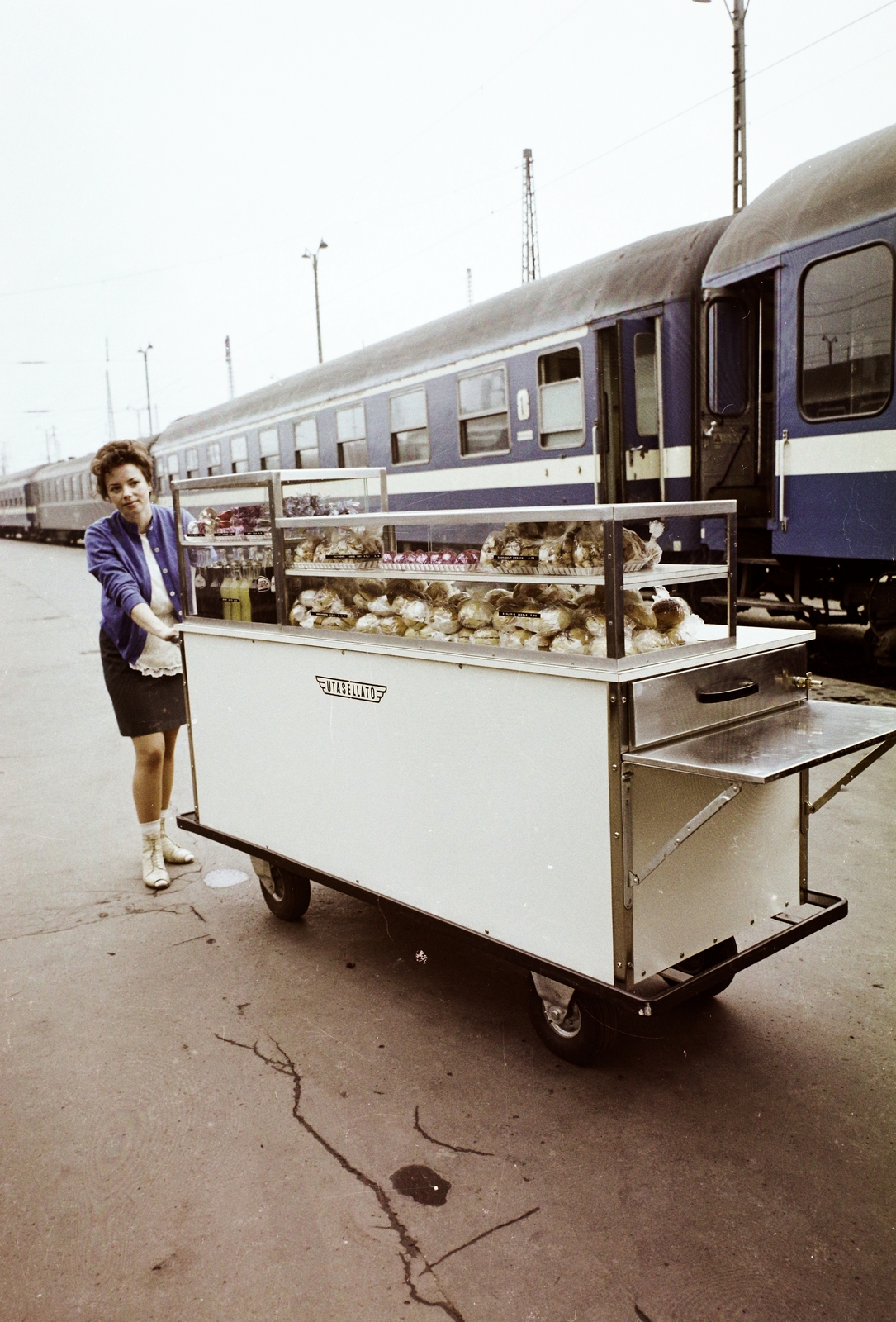 Magyarország, Budapest VI., Nyugati pályaudvar, az Utasellátó mozgó elárusító helye., 1976, Bauer Sándor, színes, utasellátó, árus, Budapest, embléma, mozgóárus, Fortepan #109887