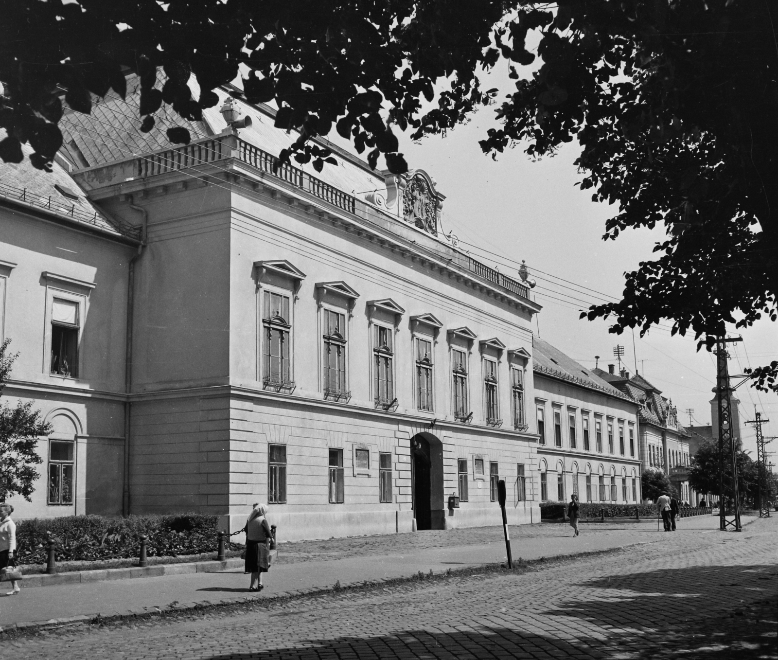 Hungary, Balassagyarmat, Civitas Fortissima (Köztársaság) tér a Rákóczi fejedelem út felé nézve. Vármegyeháza (később Mikszáth Kálmán Gimnázium, Szakközépiskola és Szakiskola). Távolabb a Szentháromság-templom (Nagytemplom)., 1960, Bauer Sándor, public building, Fortepan #109946