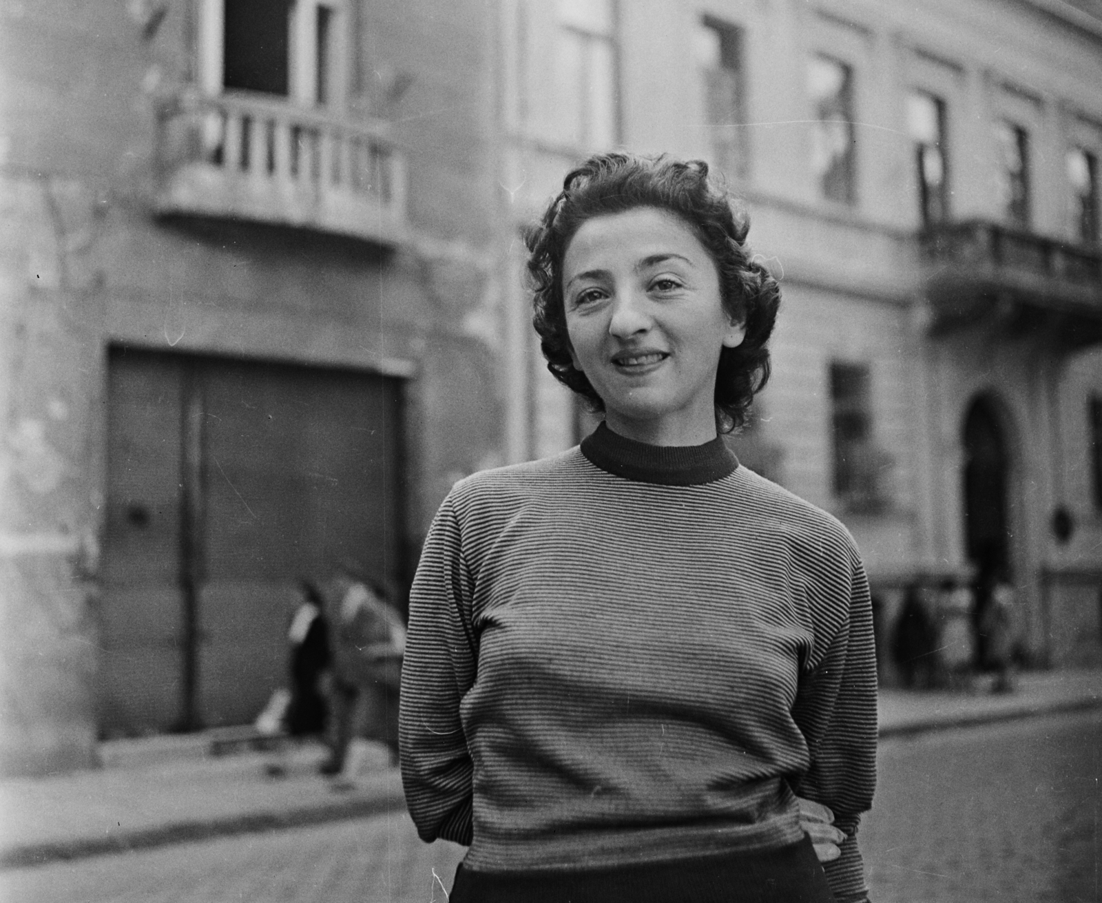 Hungary, Budapest VII., Almássy tér, háttérben a 3. és a 2. számú ház., 1956, Bauer Sándor, portrait, smile, gloves, woman, Budapest, hands behind the back, vanished building, Fortepan #110055