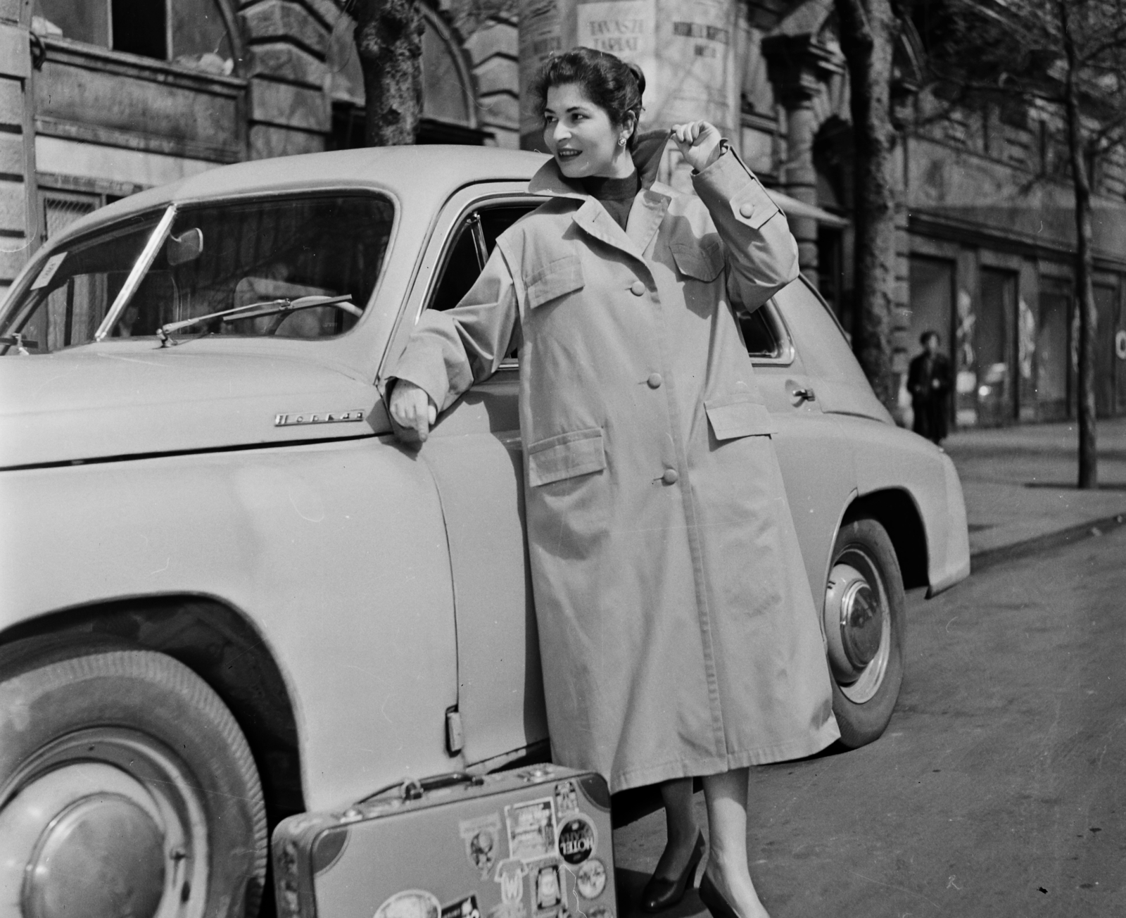 Hungary, Budapest VI., Andrássy út (Népköztársaság útja), Pobjeda típusú személygépkocsi a 4-es számú ház előtt. Garabuczy Ágnes manöken., 1957, Bauer Sándor, fashion, shoe, street view, suitcase, ad pillar, automobile, M20 Pobeda, Budapest, suitcase stickers, girls'n'cars, Fortepan #110347
