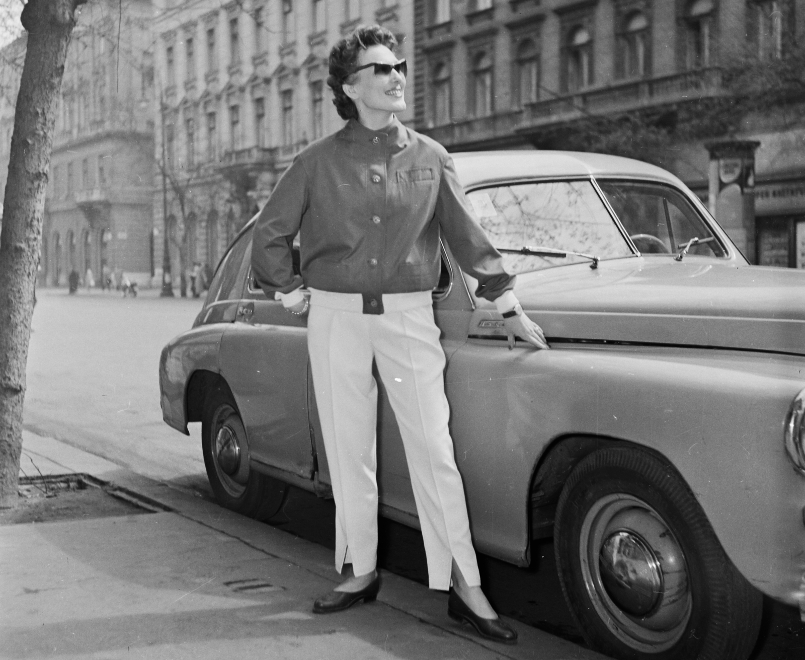 Hungary, Budapest VI., Andrássy út (Népköztársaság útja), Pobjeda típusú személygépkocsi a 4-es szám előtt, szemben a 9-es és a 7-es számú ház látszik., 1957, Bauer Sándor, fashion, shoe, shades, automobile, M20 Pobeda, Budapest, girls'n'cars, Fortepan #110349