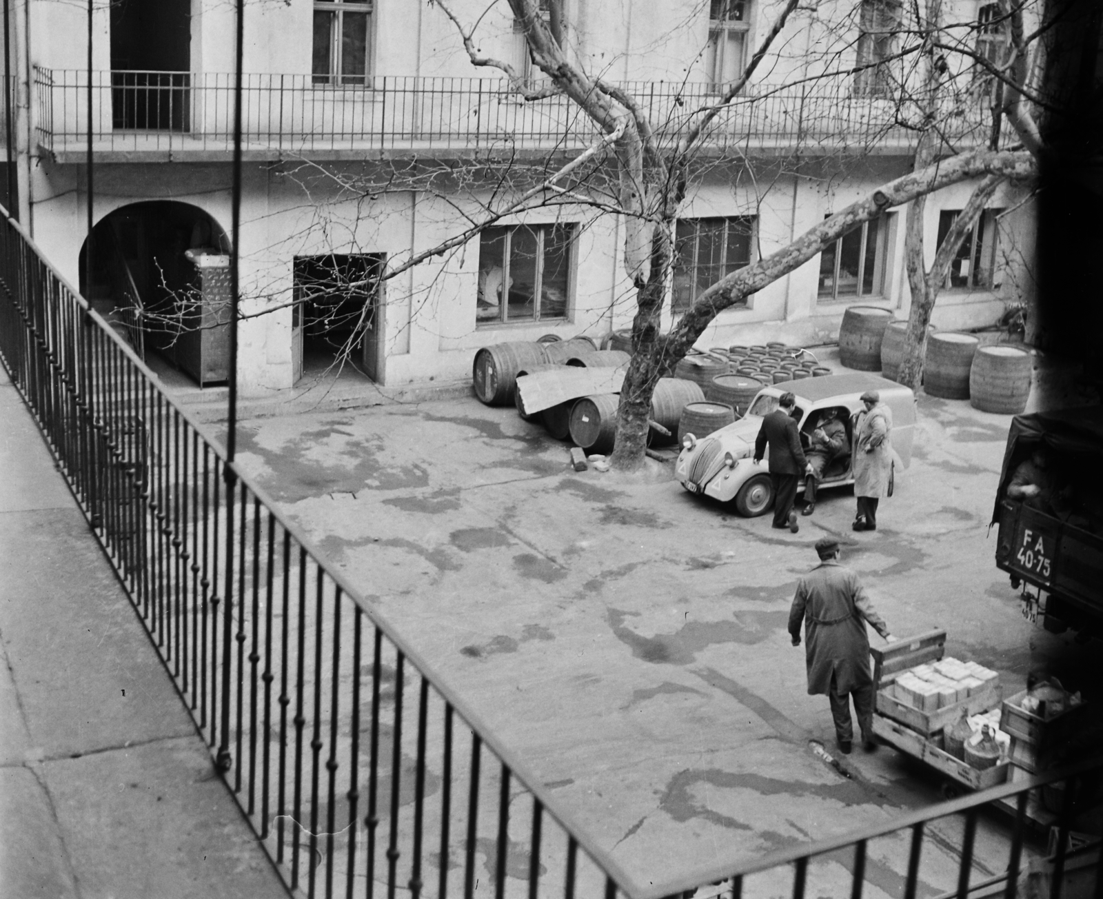Hungary, Budapest VIII., Puskin utca 6., az Éttermi és Büfé Vállalat udvara., 1957, Bauer Sándor, yard, courtyard balcony, tenement house, commercial vehicle, wood, barrel, beret, handbarrow, automobile, overall, demijohn, number plate, Budapest, Fortepan #110354