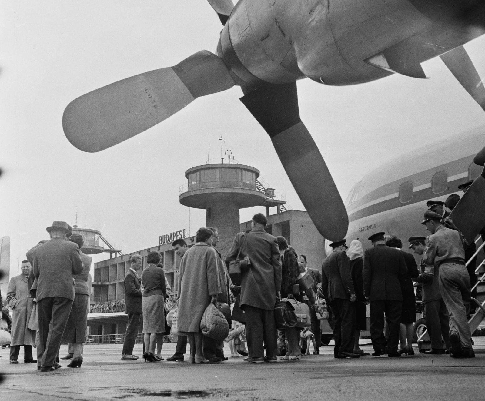 Magyarország, Ferihegyi (ma Liszt Ferenc) repülőtér, Budapest XVIII., a felvétel a magyar labdarúgó válogatott Hollandia elleni (3:0) 1961. április 28-i VB selejtezőre való indulásakor készült., 1961, Bauer Sándor, felirat, repülőgép, repülőtér, Lockheed-márka, Lockheed L-188 Electra, Budapest, irányítótorony, reptéri lépcső, légcsavar, Fortepan #110560