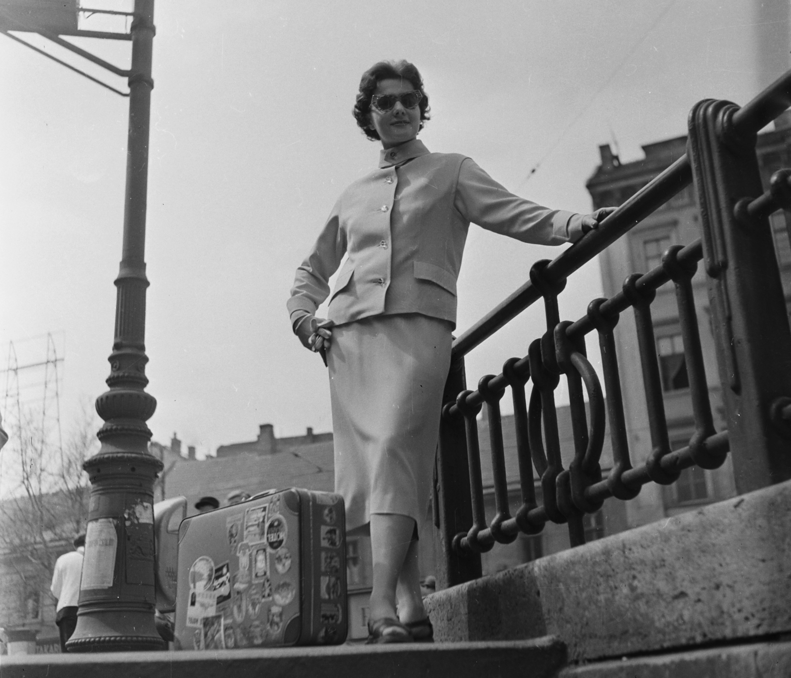 Hungary, Budapest VI., Andrássy út (Népköztársaság útja) - Bajcsy Zsilinszky út sarok, a Millenniumi Földalatti Vasút állomásának lejárója. Vitéz Eszter manöken., 1957, Bauer Sándor, fashion, suitcase, shades, gloves, costume, Budapest, suitcase stickers, Fortepan #112897