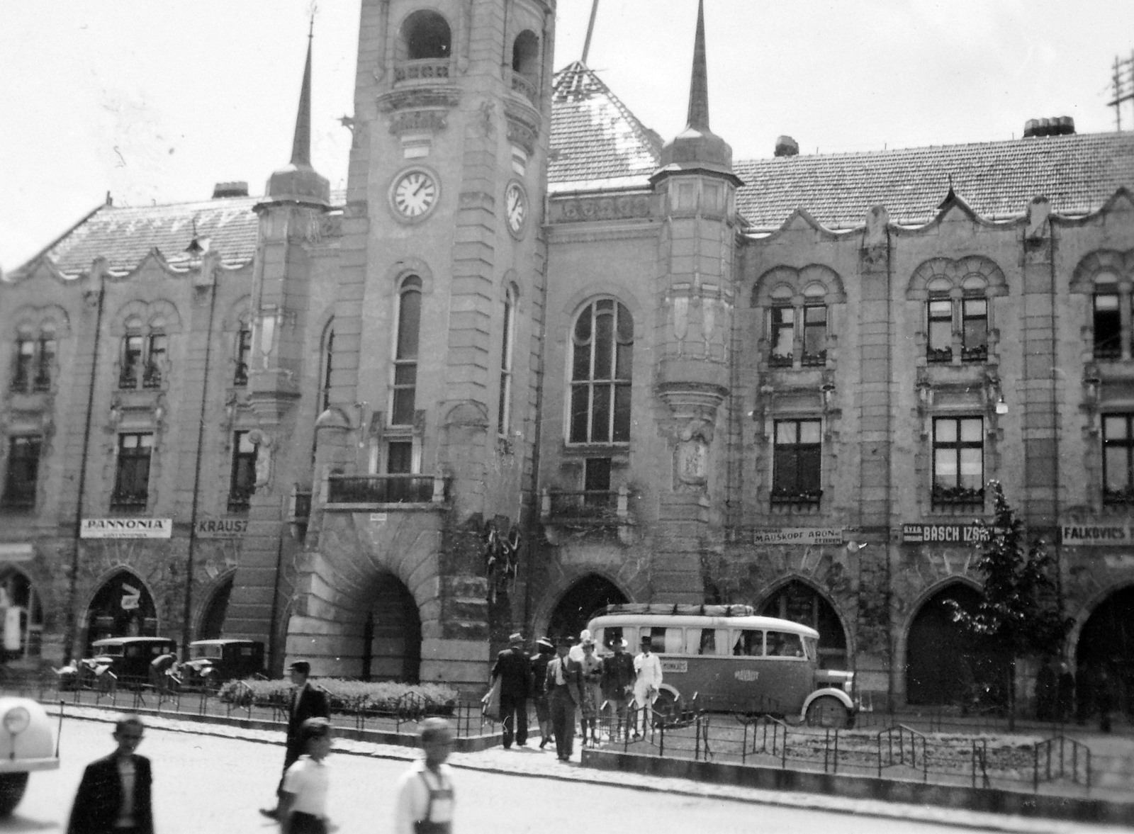 Ukraine,Zakarpattia Oblast, Mukachevo, Duhnovics (ekkor Horthy Miklós) tér, Városháza., 1940, Gyöngyi, bus, MÁVAUT-organisation, store display, public building, automobile, church clock, Art Nouveau architecture, János Bobula Jr.-design, Fortepan #11459