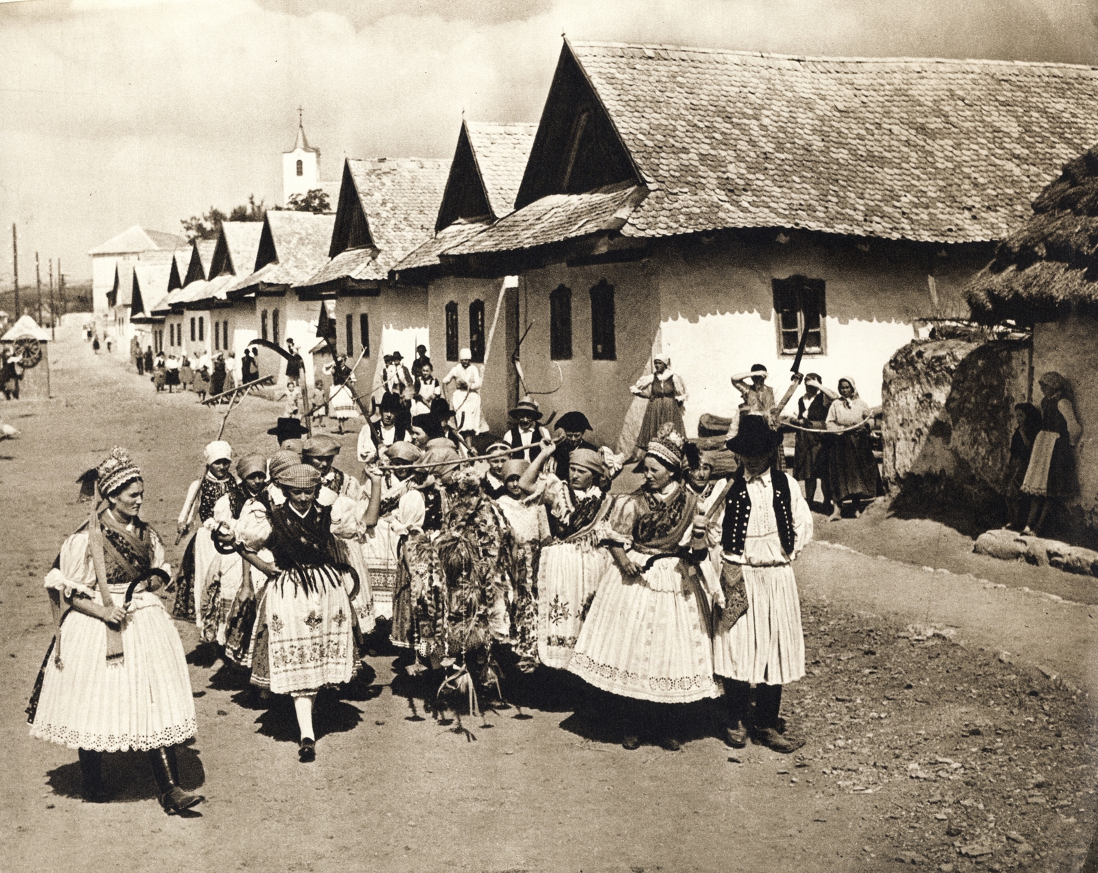 Hungary, Kazár, Kossuth Lajos út, háttérben a Szent Ilona-templom. Aratóünnep., 1940, Buzinkay Géza, village, folk costume, farmhouse, Fortepan #114612