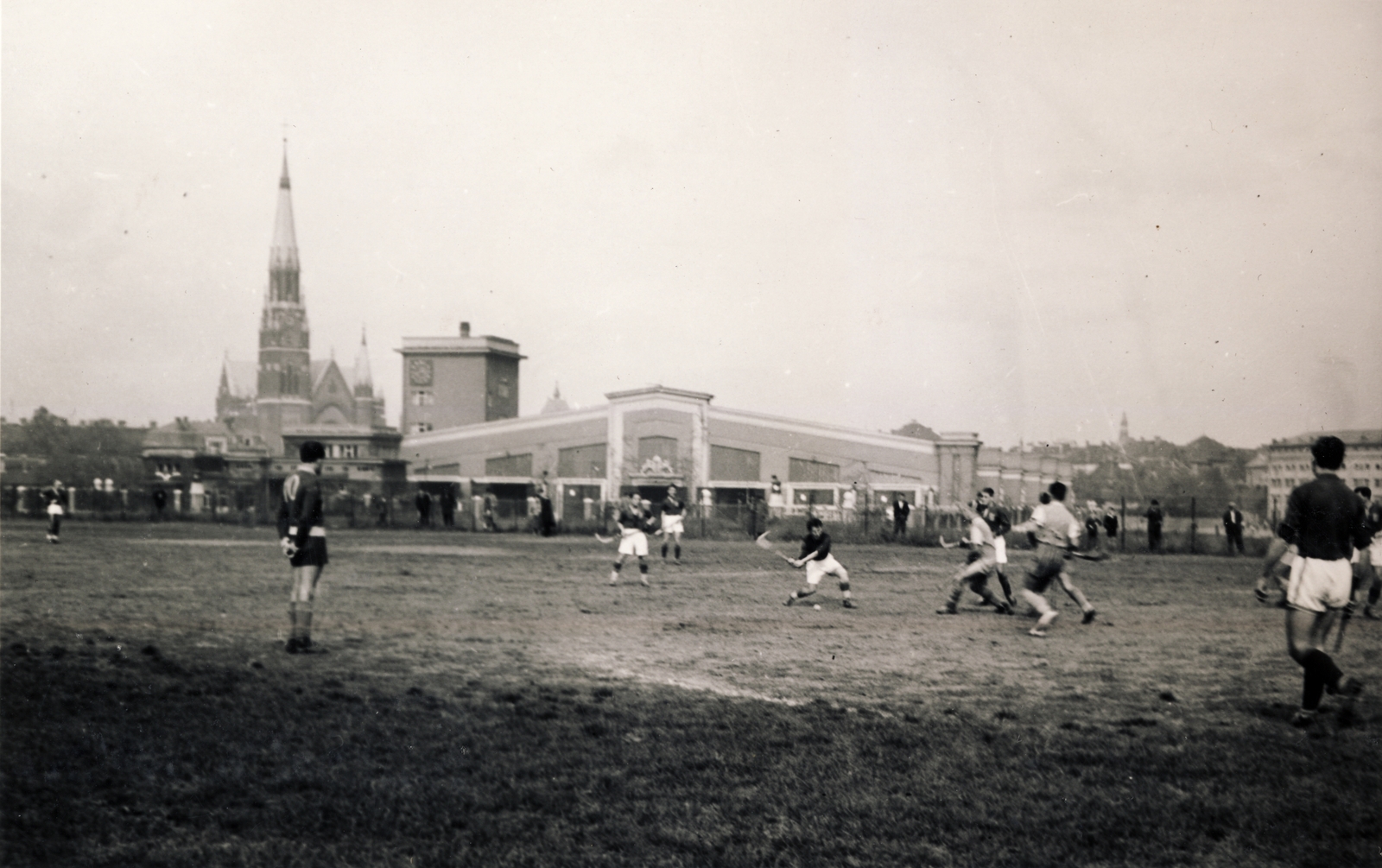 Magyarország, Budapest XIV., előterében a Magyar Hockey Club (MHC) gyeplabdaklubjának az korábbi lóversenytér területén, a Dózsa György (Aréna) út és a Verseny utca találkozásánál kialakított pályája látható. Háttérben a Szent Domonkos (később Récsei) autóbuszgarázs, balra a Rózsafüzér Királynéja-templom a Thököly úton., 1930, Buzinkay Géza, sport, gyeplabda, Budapest, buszgarázs, Fortepan #114666