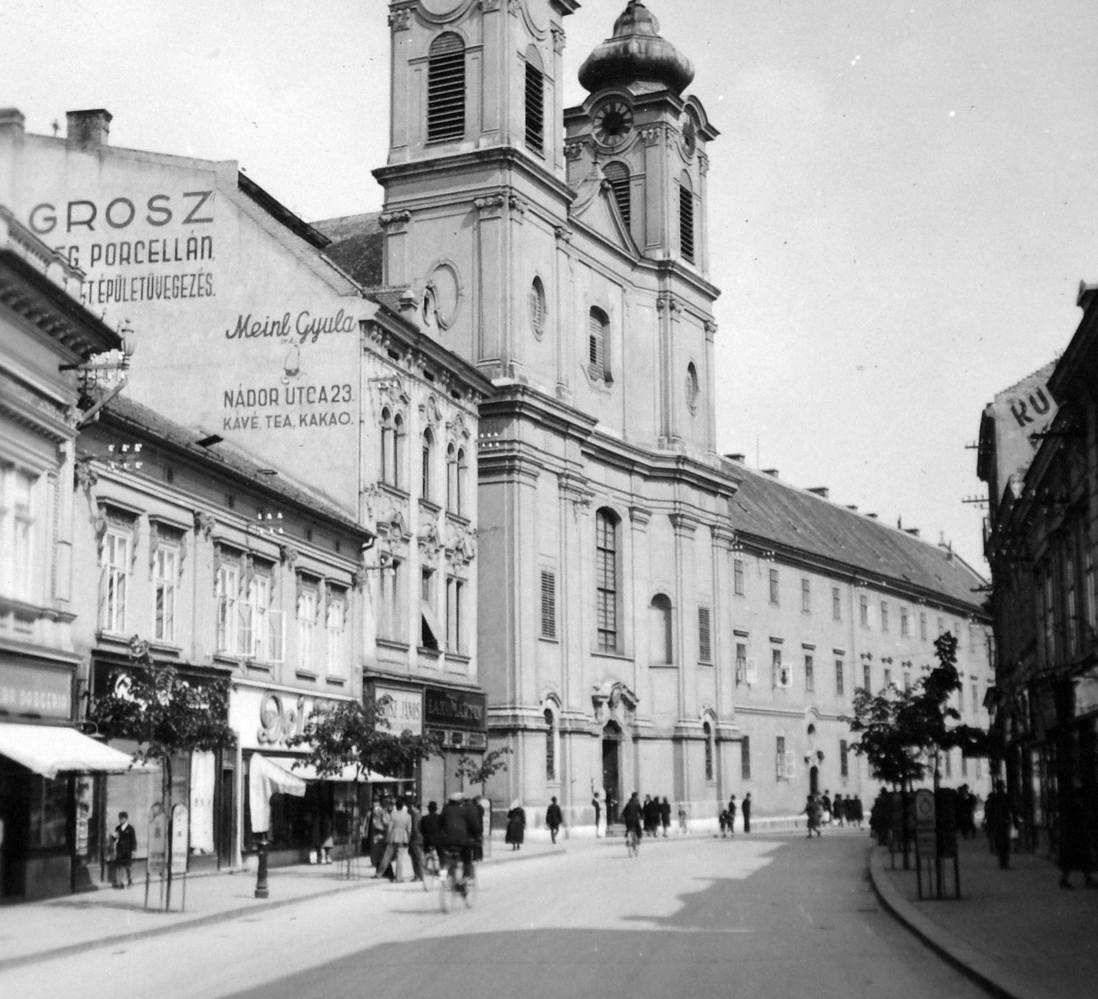 Hungary, Székesfehérvár, Fő (Nádor) utca, szemben a Nepomuki Szent János-templom és rendház., 1940, Gyöngyi, ad, church, street view, Baroque-style, store display, Catholic Church, Julius Meinl-brand, Paul Hatzinger-design, Fortepan #11471