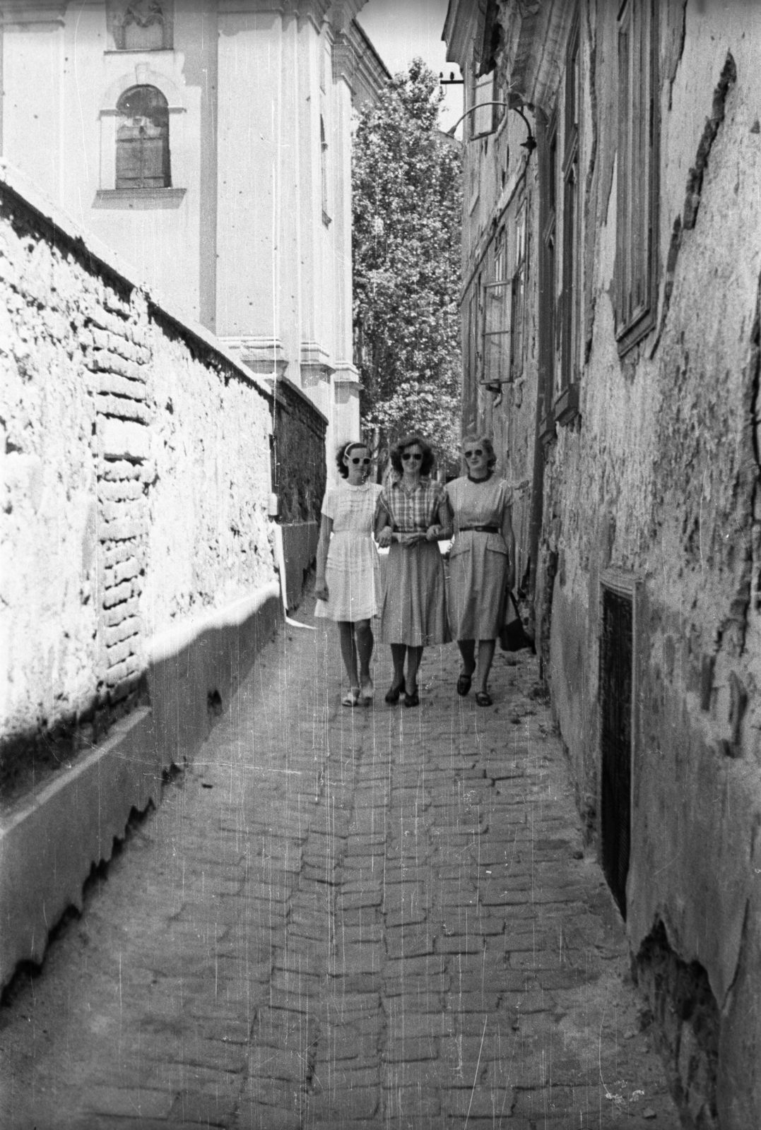 Magyarország, Székesfehérvár, Templom köz, háttérben balra a Szent István-székesegyház., 1957, Répay András, nők, sikátor, kart karba öltve, Fortepan #115445