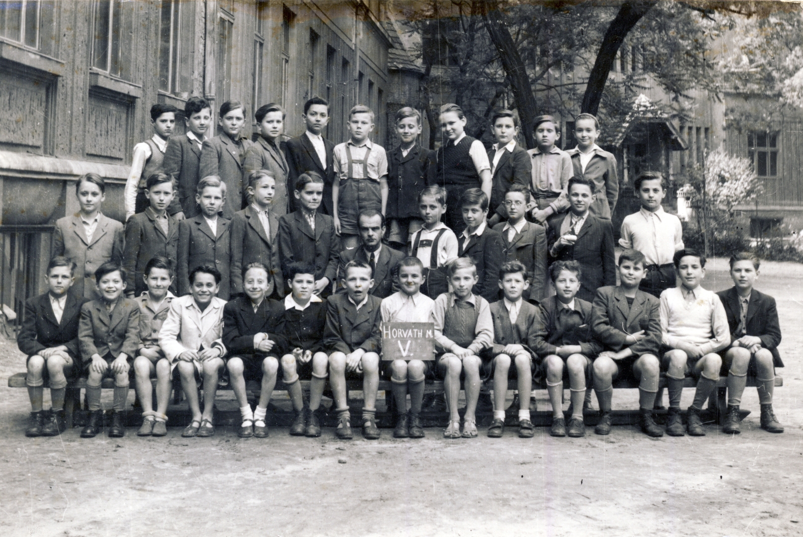 Hungary, Budapest VIII., Horváth Mihály tér 8., a Horváth Mihály téri Gyakorló Általános Iskola (később Fazekas Mihály Gyakorló Általános Iskola és Gimnázium) udvara. Osztálykép az ötödikes fiúosztályról. Az első sorban balról a hatodik, Simon Balázs (később festő, grafikus), jobbról az ötödik Szabó istván (később filmrendező). A második sorban balról a negyedik, Sztranyavszky Madách Ádám (Madách Imre unokája). A hátsó sorban jobbról az ötödik Rózsa János (később filmrendező)., 1949, Fortepan/Album009, Budapest, class photo, board, tie, knee snocks, Fortepan #116484