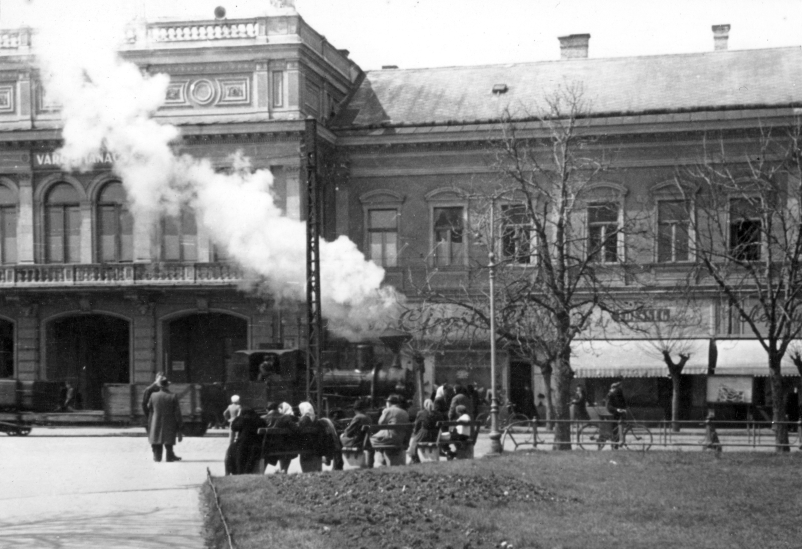 Hungary, Nyíregyháza, Kossuth tér, az NyVKV (Nyíregyházavidéki Kisvasutak) szerelvénye a villamossal közös pályaszakaszon, a Városi Tanács (később Városháza) előtt., 1957, Vojnich Pál, steam locomotive, narrow-gauge railway, Fortepan #116610