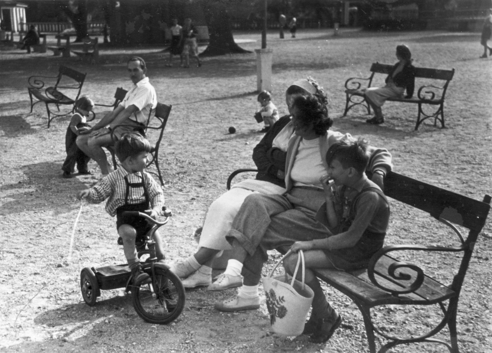 Hungary,Lake Balaton, Keszthely, park a kikötőnél, háttérben a Szigetfürdő / Sziget-strand bejárója., 1956, Vojnich Pál, bench, kid, leg over leg, mother, kids' tricycles, Fortepan #116618