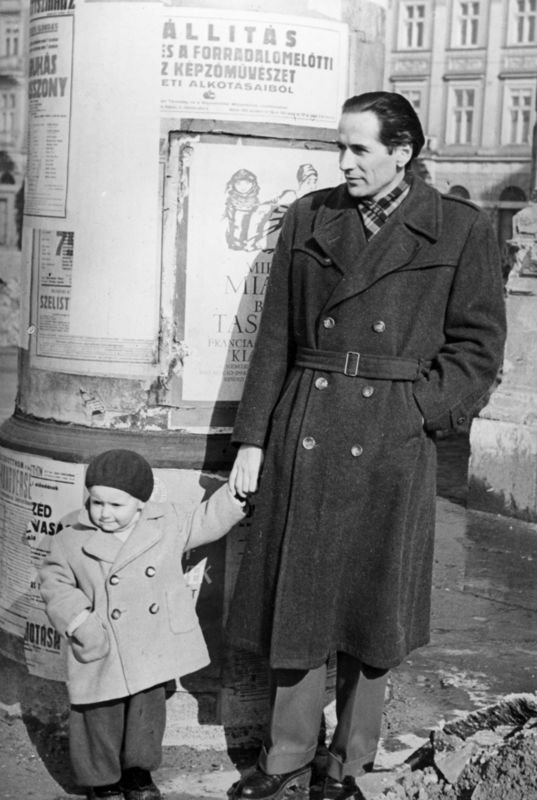 Hungary, Budapest V., Dunakorzó a Wekerle Sándor (Szende Pál) utcánál, háttérben az Apáczai Csere János utca 15., 1956, Vojnich Pál, ad pillar, Budapest, hands in pockets, double-breasted coat, hold hands, Fortepan #116621