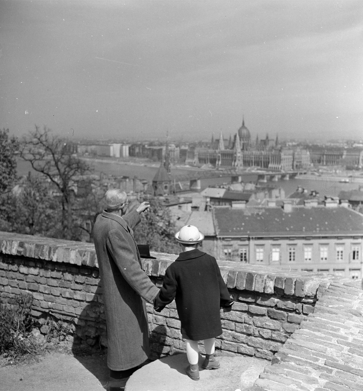 Hungary, Budapest I., Szentháromság tér, játszótér a Tárnok utca alatt. Kilátás a keleti várfal mellvédjétől a Kossuth híd és a Parlament felé., 1958, FSZEK Budapest Gyűjtemény / Sándor György, Sándor György, Kossuth-bridge, Budapest, hold hands, grandparent, girl, Fortepan #116835