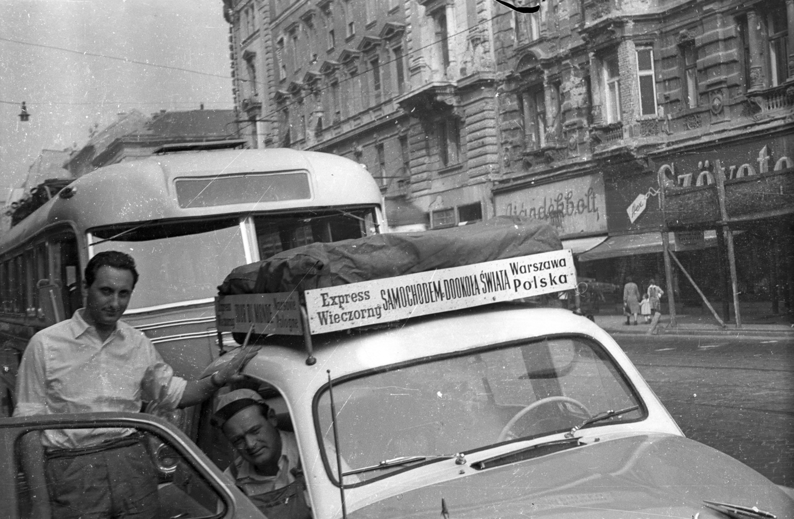 Hungary, Budapest VII., Rákóczi út, Ryszard Sługocki és Zygmunt Rzezuchowski lengyel újságírók, Warszawa típusú gépkocsijukkal, világ körüli útjuk során álltak meg a fővárosban. Szemben a háttérben a Csemege Áruház / éjjel-nappal közért épülete az Erzsébet (Lenin) körút sarkán., 1957, FSZEK Budapest Gyűjtemény / Sándor György, Sándor György, Budapest, celebrity, Fortepan #117149