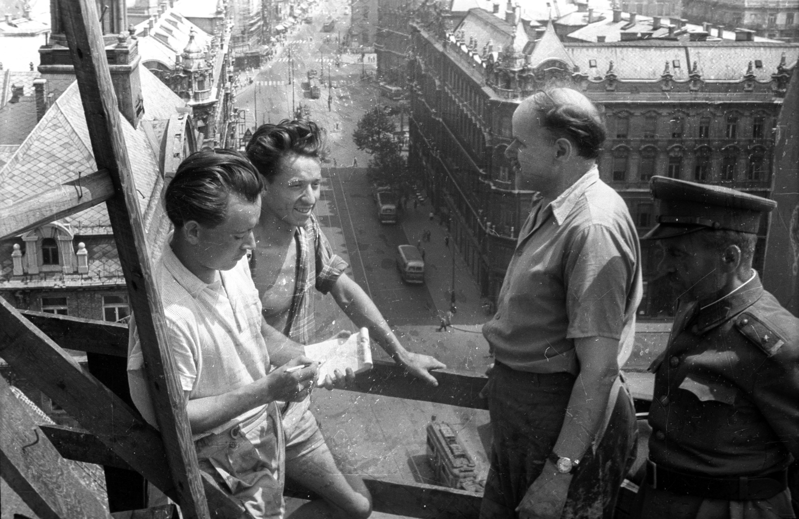 Hungary, Budapest V., kilátás a felállványozott Belvárosi templom déli tornyából a Szabad sajtó út és a Ferenciek tere (Felszabadulás tér) felé., 1958, FSZEK Budapest Gyűjtemény / Sándor György, Sándor György, Budapest, uniform, wrist watch, notebook, talks, railing, Fortepan #117171