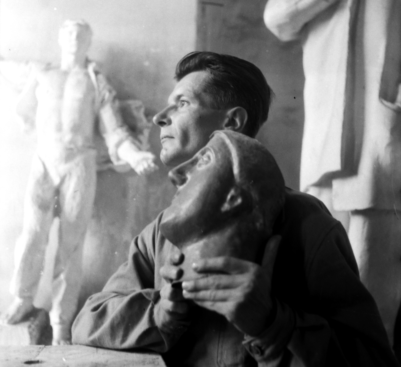 Magyarország, Budapest I., Várkert Bazár, Megyeri Barna szobrászművész a műtermében. Háttérben balra a Prométheusz című épületdísz gipszmintája., 1956, Aradi Péter, Szenczi Mária, műterem, híres ember, Budapest, Fortepan #117401