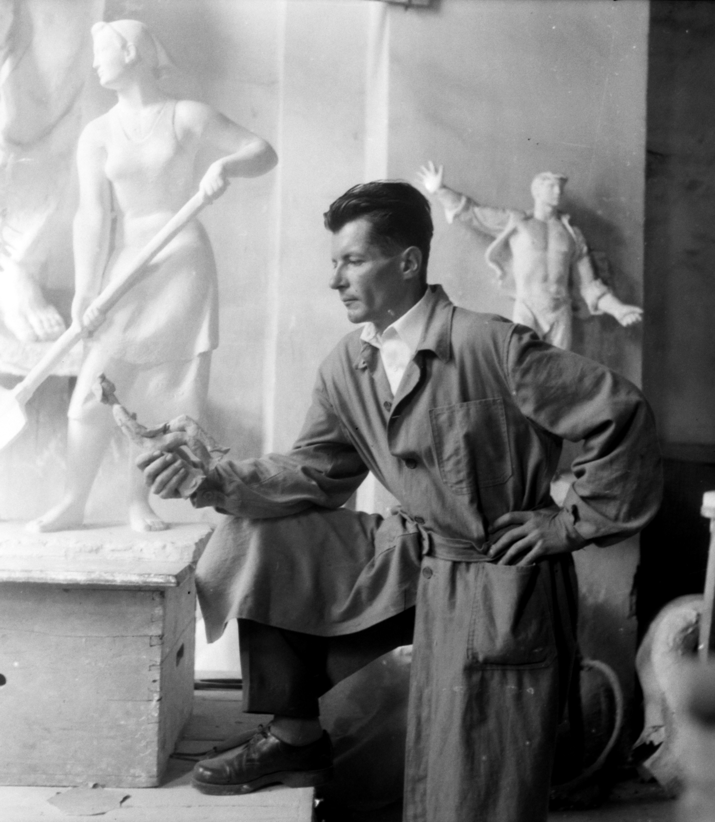 Hungary, Budapest I., Várkert Bazár, Megyeri Barna szobrászművész a műtermében. Háttérben balra a Facsemetét ültetők szoborcsoport egyik alakjának gipszmintája, jobbra a Prométheusz című épületdísz gipszmintája., 1956, Aradi Péter, Szenczi Mária, studio, sculptor, sculpture, posture, Budapest, Best of, Fortepan #117406