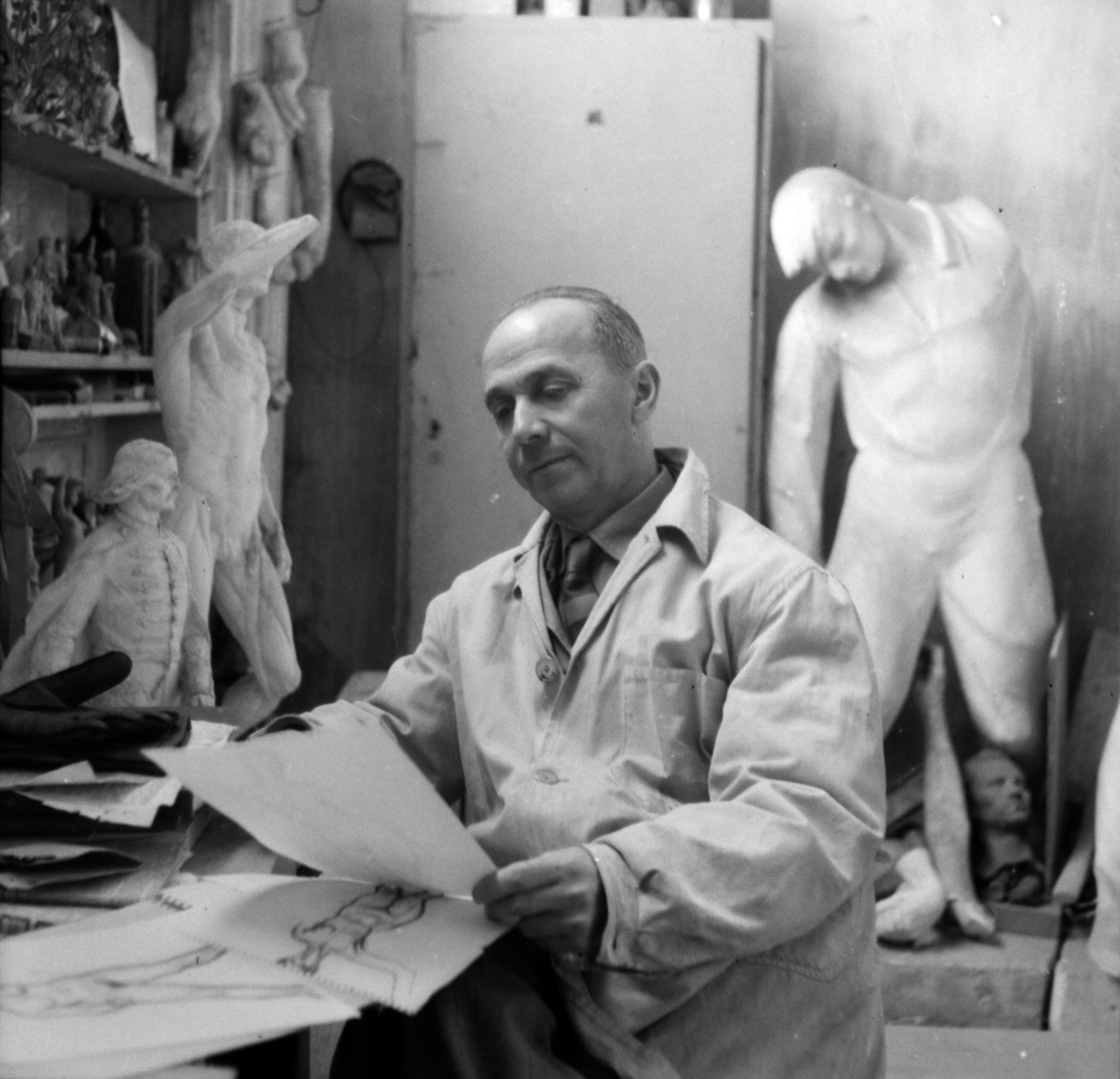 Magyarország, Olcsai Kiss Zoltán szobrászművész. Háttérben jobbra a Munkásmozgalmi Pantheon egyik alakjának gipszmintája., 1956, Aradi Péter, Szenczi Mária, munkaköpeny, híres ember, portré, Fortepan #117432