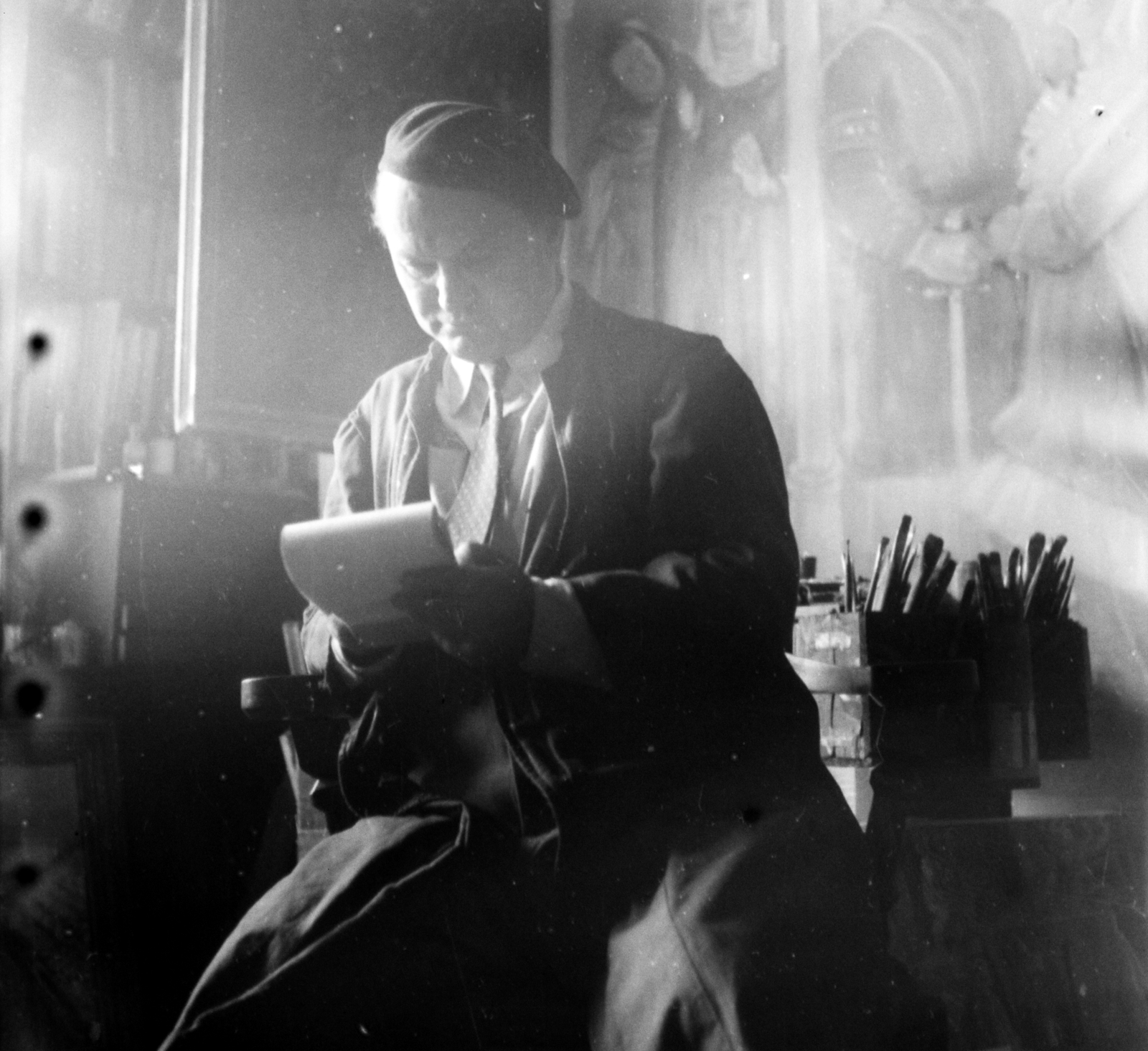 Hungary, Budapest VI., Epreskert, Ruzicskay György festőművész műtermében, háttérben a Bánk Bán és Tiborc című műve., 1955, Aradi Péter, Szenczi Mária, Budapest, studio, photo aspect ratio: square, overall, reading, painter tools, backlight, Fortepan #117464