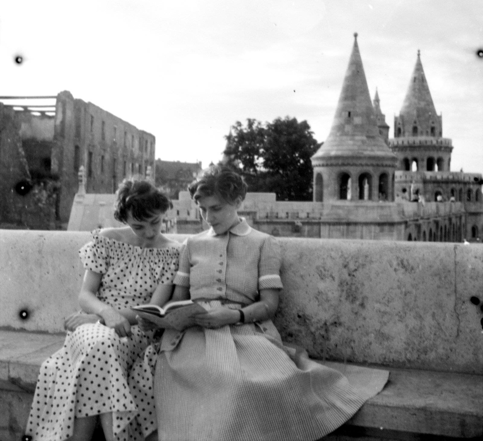 Magyarország, budai Vár,Halászbástya, Budapest I., a háttérben balra az egykori jezsuita kollégium romos épülete., 1956, Aradi Péter, Szenczi Mária, Budapest, pöttyös ruha, nők, olvasás, pad, Schulek Frigyes-terv, Fortepan #117487