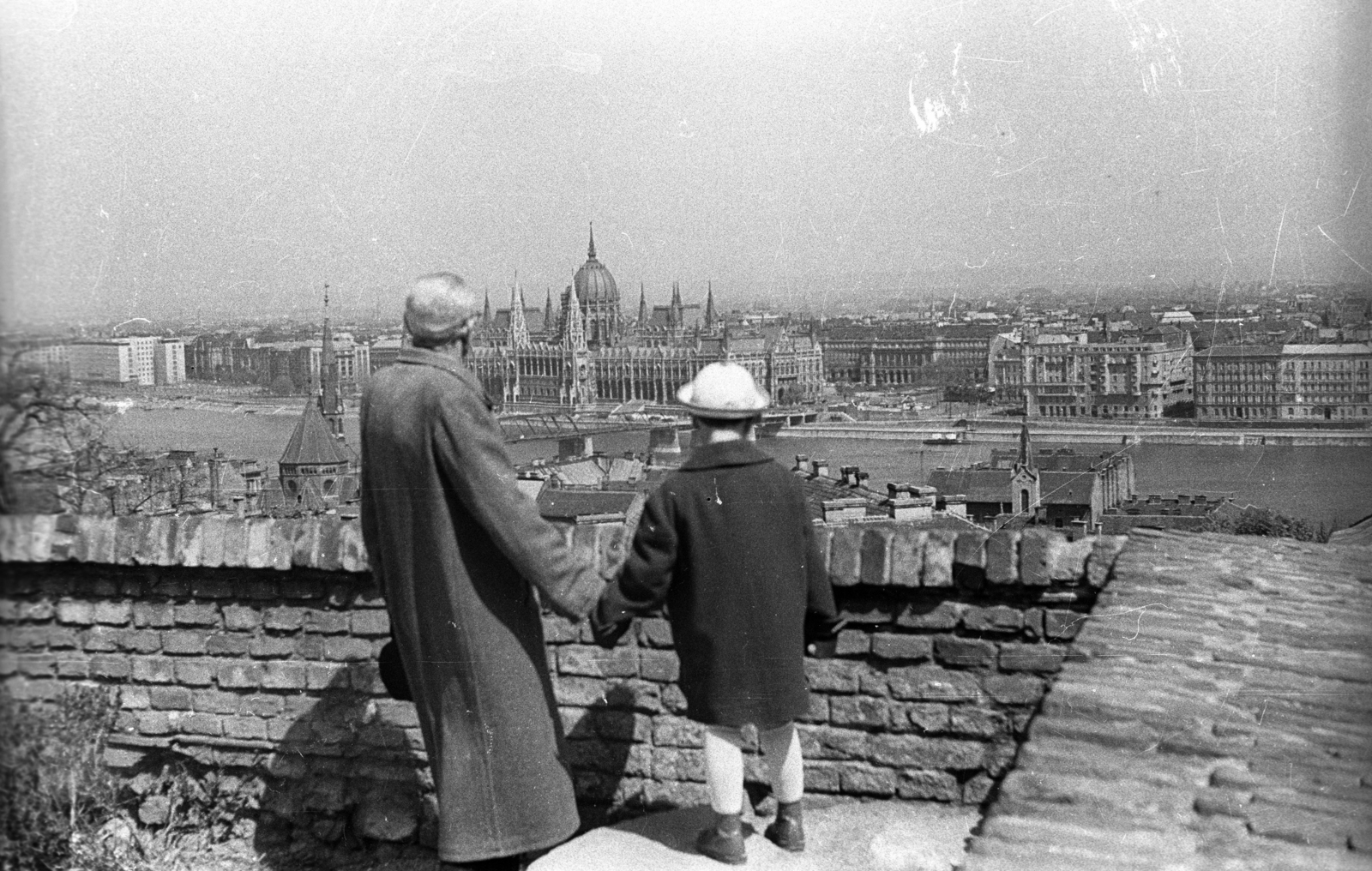 Hungary, Budapest I., Szentháromság tér, játszótér a Tárnok utca alatt. Kilátás a keleti várfal mellvédjétől a Kossuth híd és a Parlament felé., 1958, FSZEK Budapest Gyűjtemény / Sándor György, Sándor György, Kossuth-bridge, Budapest, grandparent, hold hands, Fortepan #119075