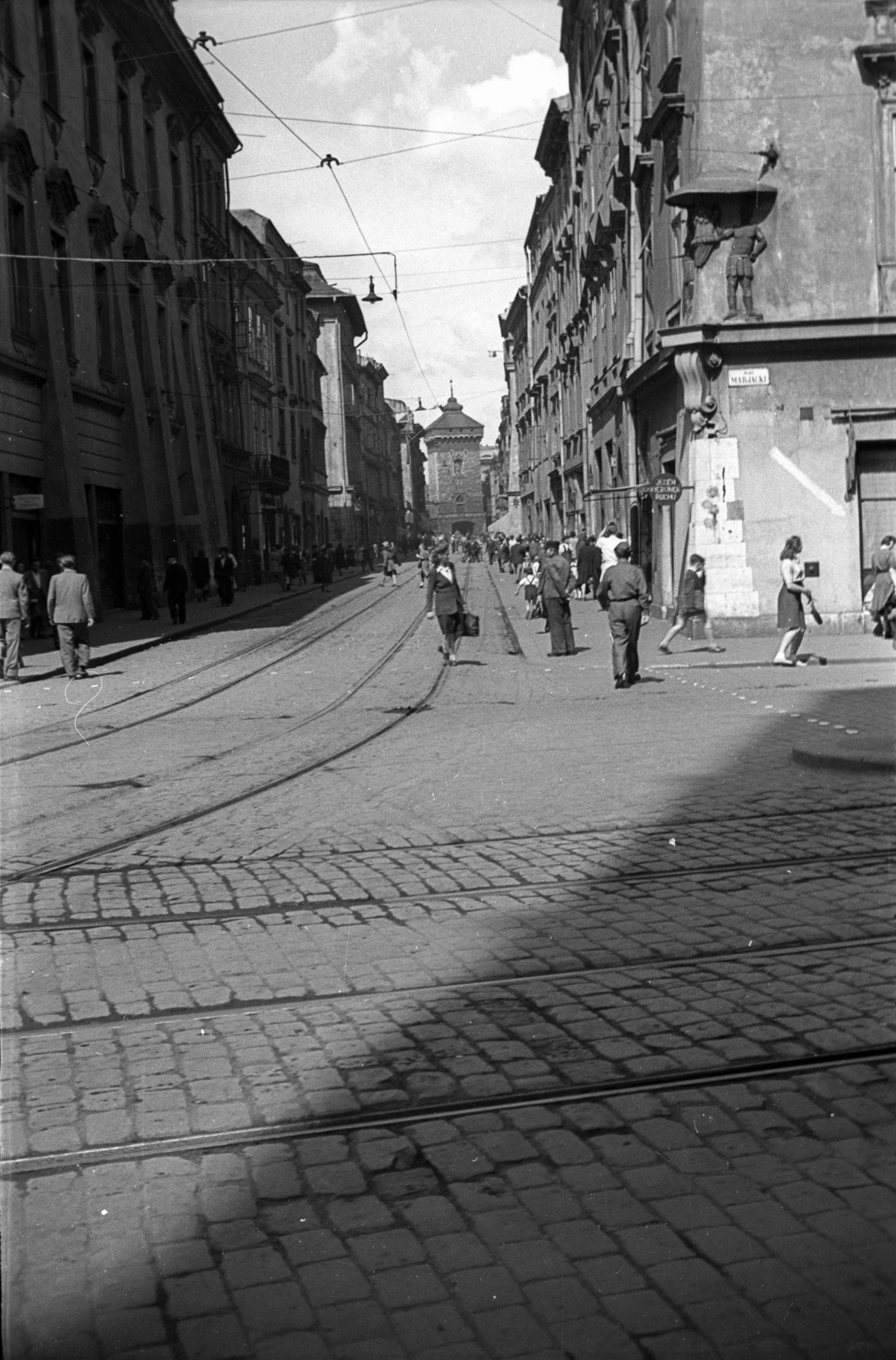 Poland, Kraków, Plac Mariacki, szemben az ulica Floriańska végén a Flórián kapu., 1947, Bogdan Celichowski, rails, street view, architectural ornament, pedestrian, relief, crosswalk, Fortepan #119188