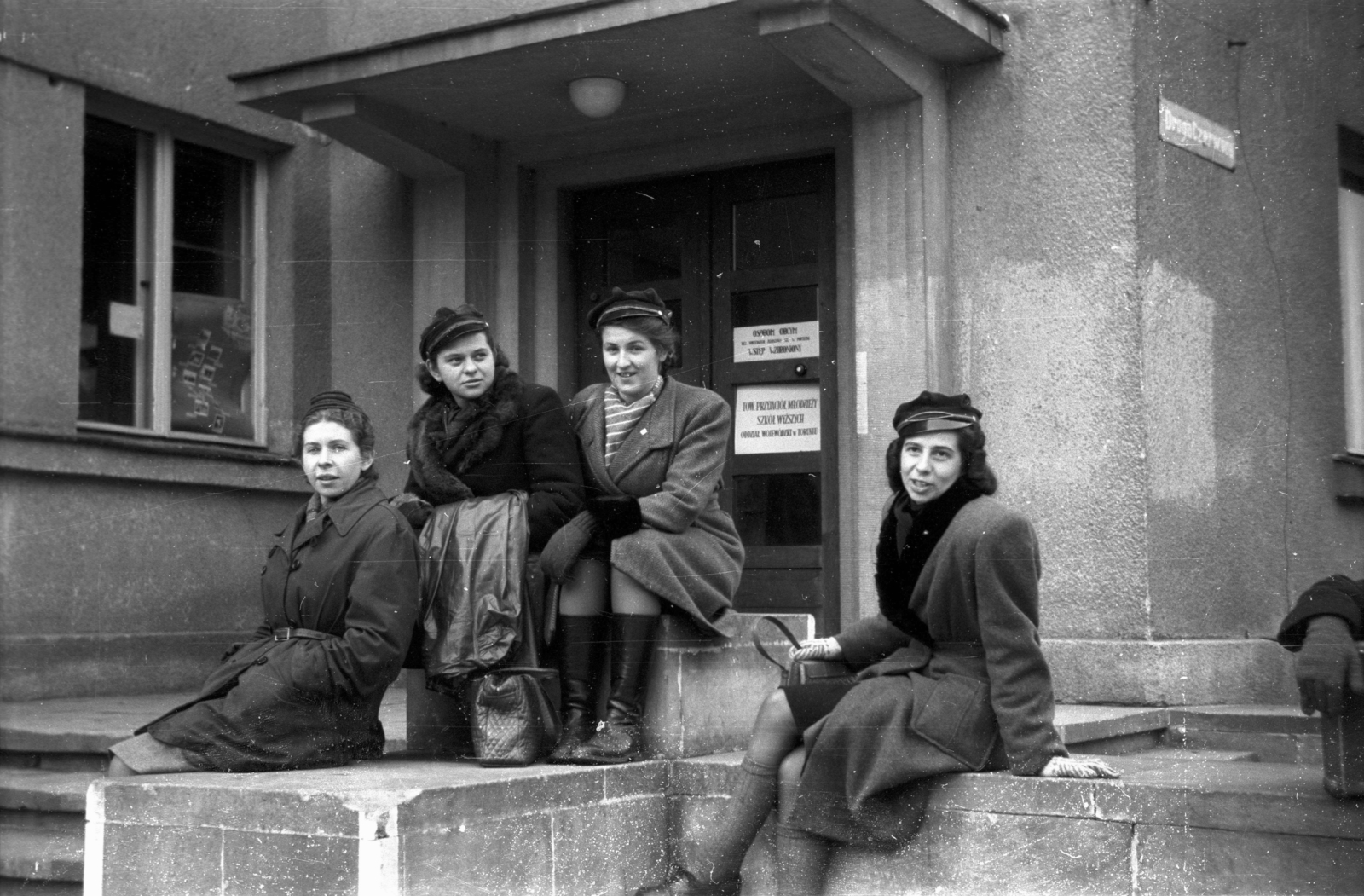 Lengyelország, Toruń, Czerwona Droga., 1946, Bogdan Celichowski, sapka, hölgy, csoportkép, ül, kabát, bejárat, Fortepan #119270