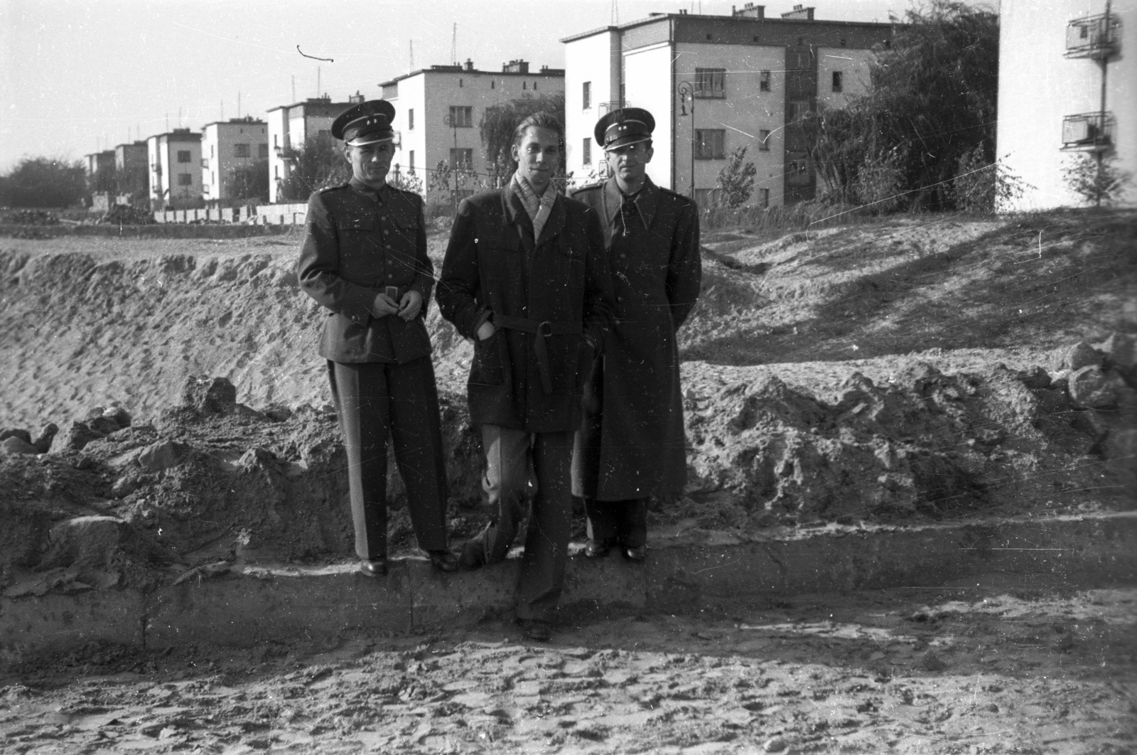 Poland, Warsaw, előtérben a mai ulica Magistracka környéke, háttérben az ulica Ożarowska épületei., 1950, Bogdan Celichowski, men, coat, soldier, hands in pockets, hands behind the back, tenement house, blocks, Fortepan #119649