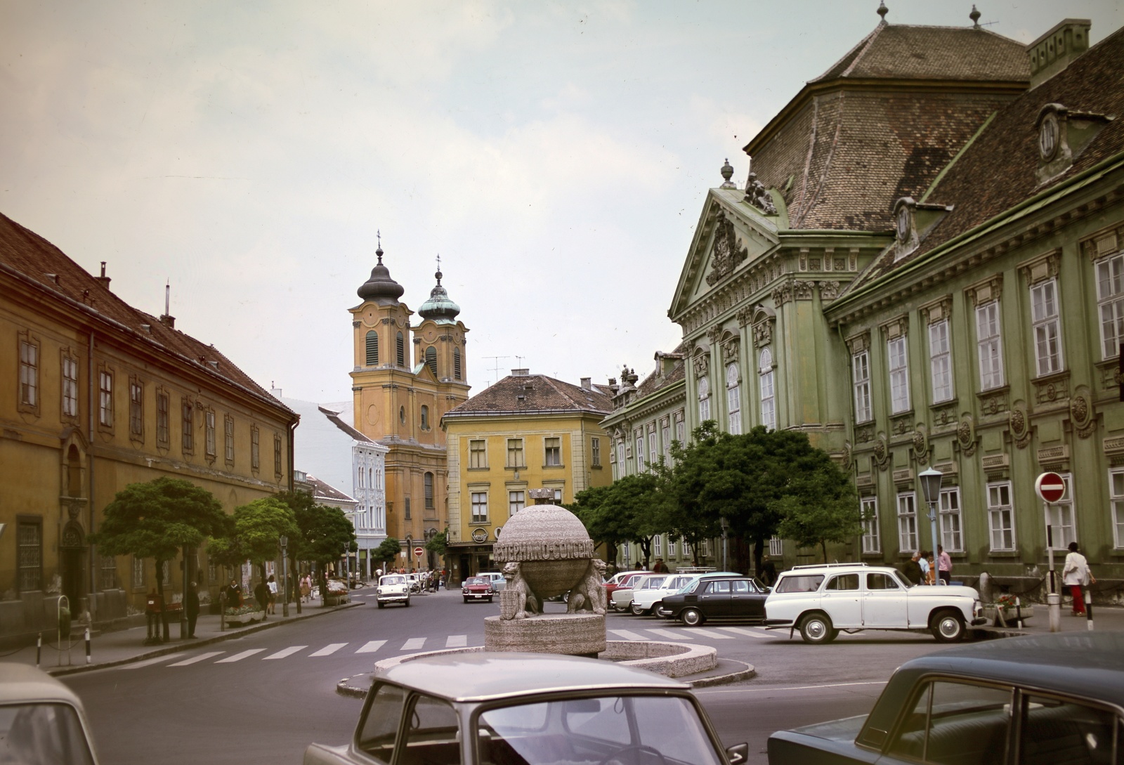 Magyarország, Székesfehérvár, Városház (Szabadság) tér, középen az Országalma (Ohmann Béla, 1943.), jobbra a Püspöki palota, szemben a Nepomuki Szent János-templom., 1971, Inkey Tibor, színes, FSO Warszawa 223, templom, köztéri szobrászat, Fortepan #120956