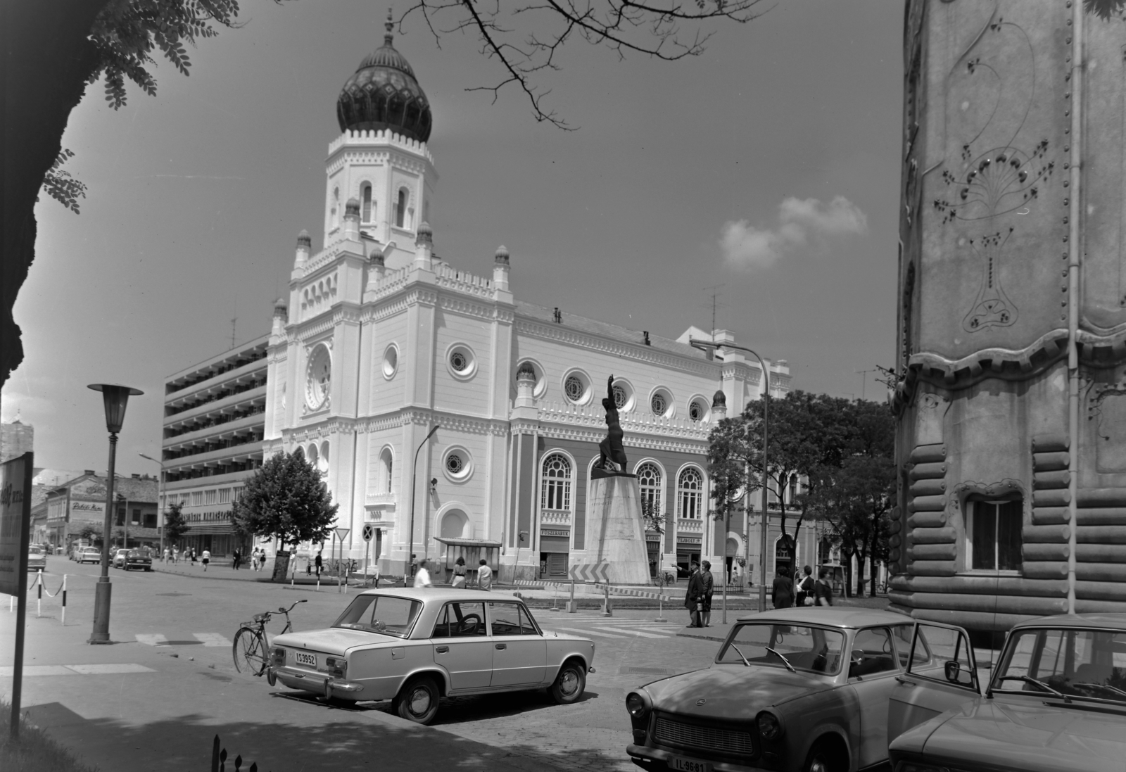 Hungary, Kecskemét, Rákóczi út - Szabadság tér sarok, középen a Tudomány és Technika Háza, korábban zsinagóga, jobbra a Cifra-palota. A két épület között a Tanácsköztársasági emlékmű (Herczeg Klára, 1959.)., 1976, Inkey Tibor, Trabant-brand, Fortepan #120957